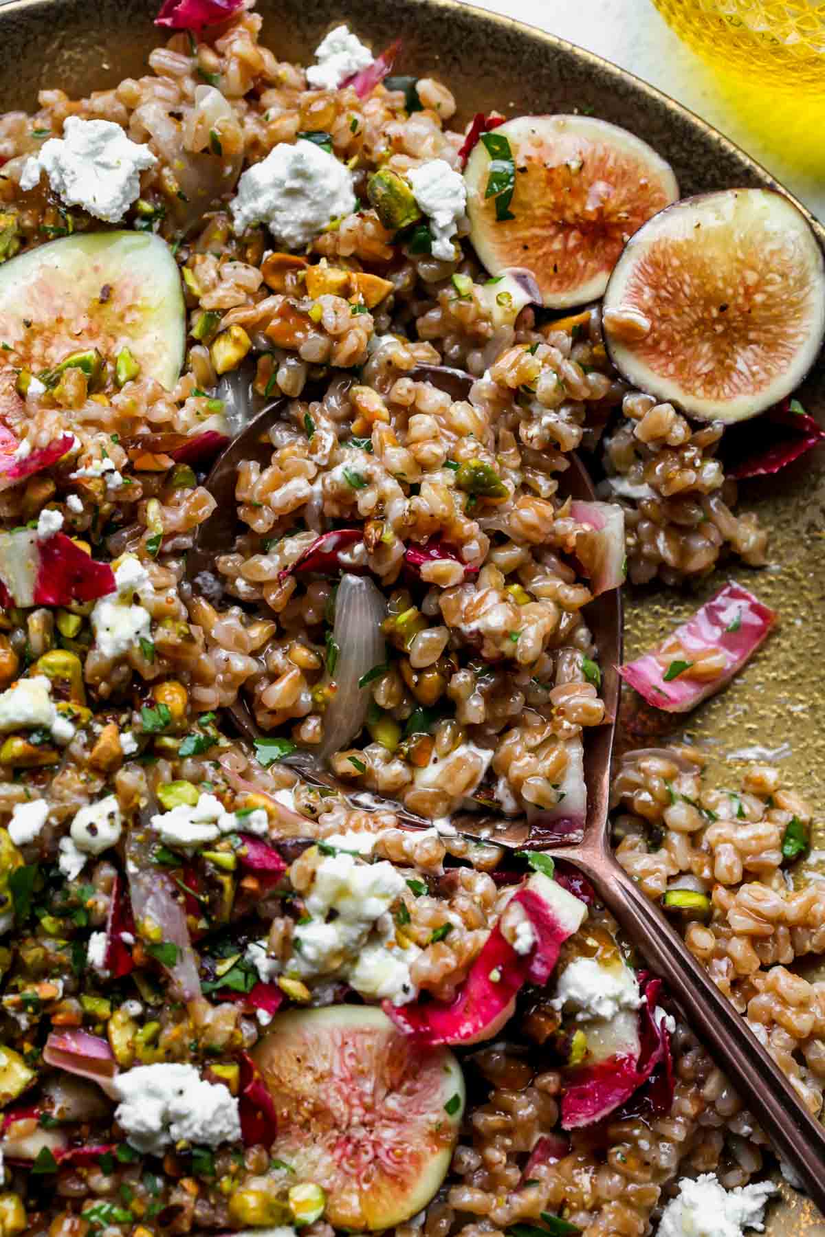 A serving spoon scooping up grain salad