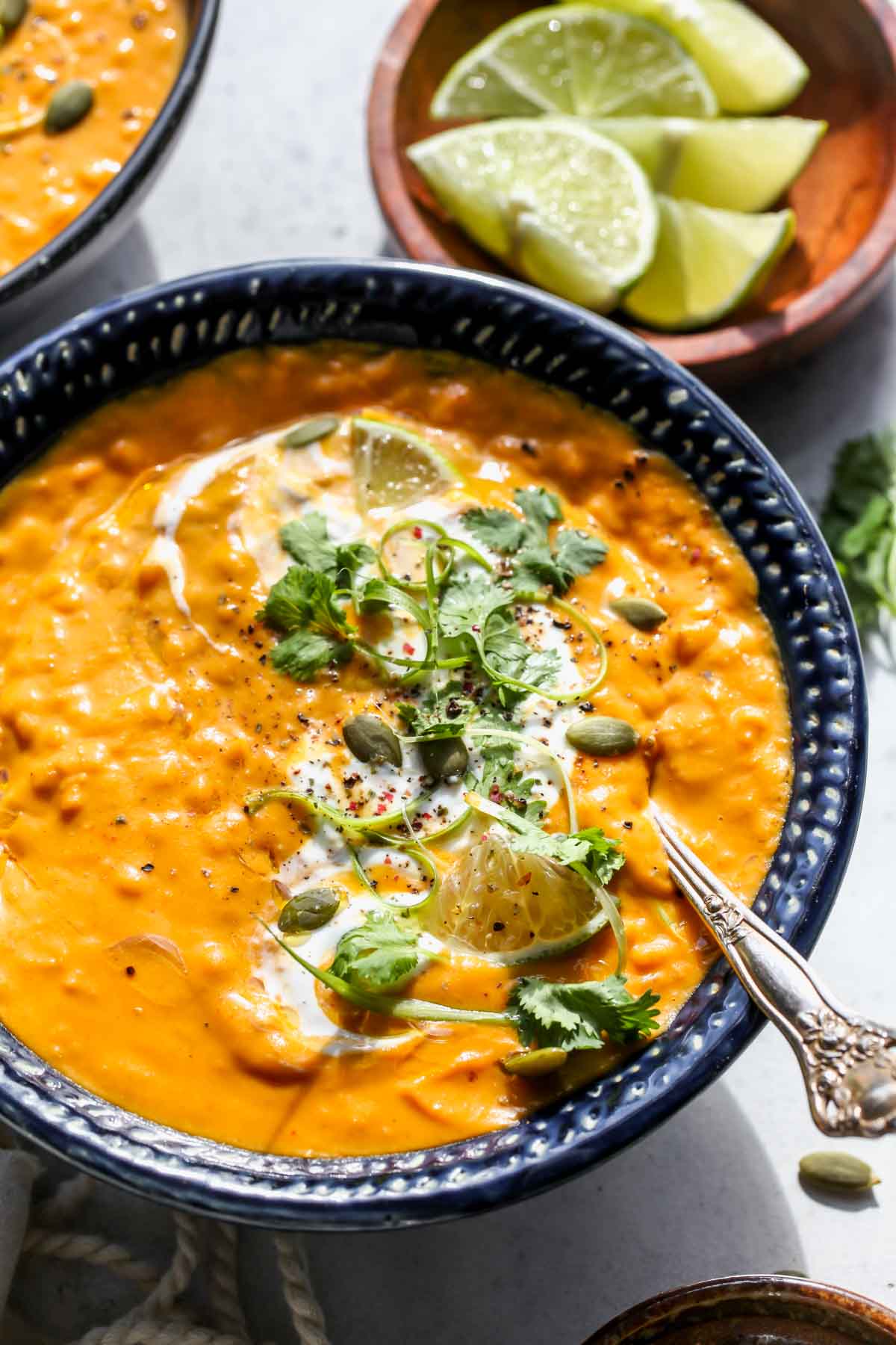 Spoon dipping into a bowl of pumpkin lentil soup