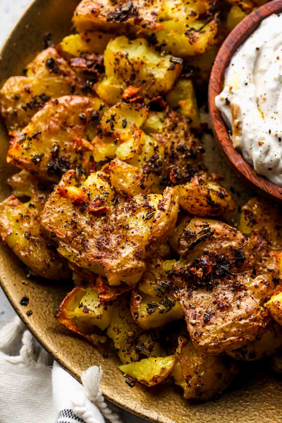 Crispy smashed potatoes on a platter stacked on one another