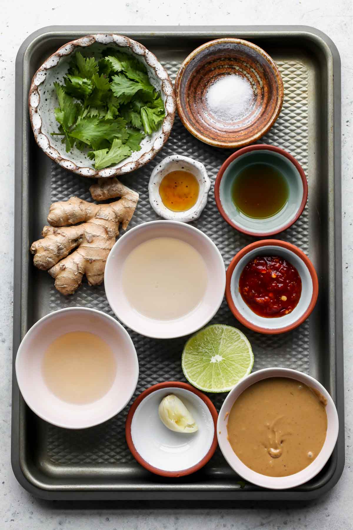 Recipe ingredients in separate bowls on a rimmed baking sheet