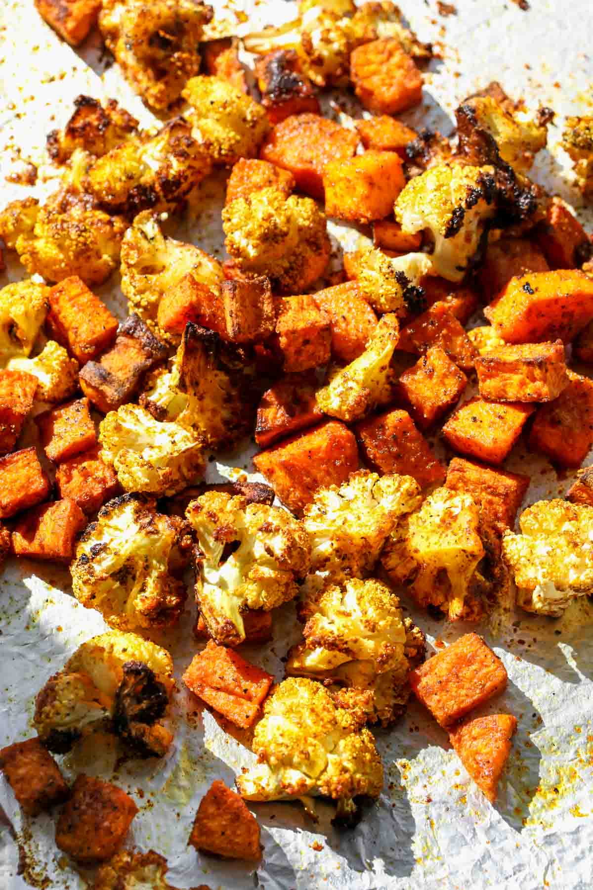 Sheet pan filled with spice-roasted cauliflower and sweet potato cubes