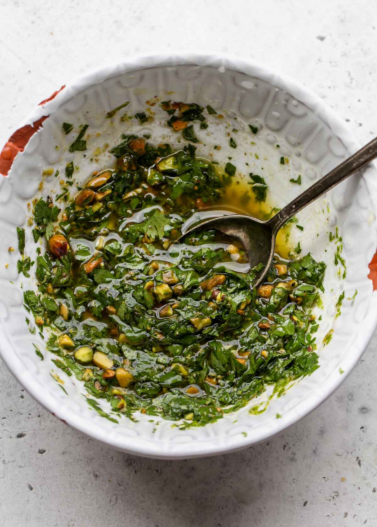 Pistachio salsa being mixed in a white bowl
