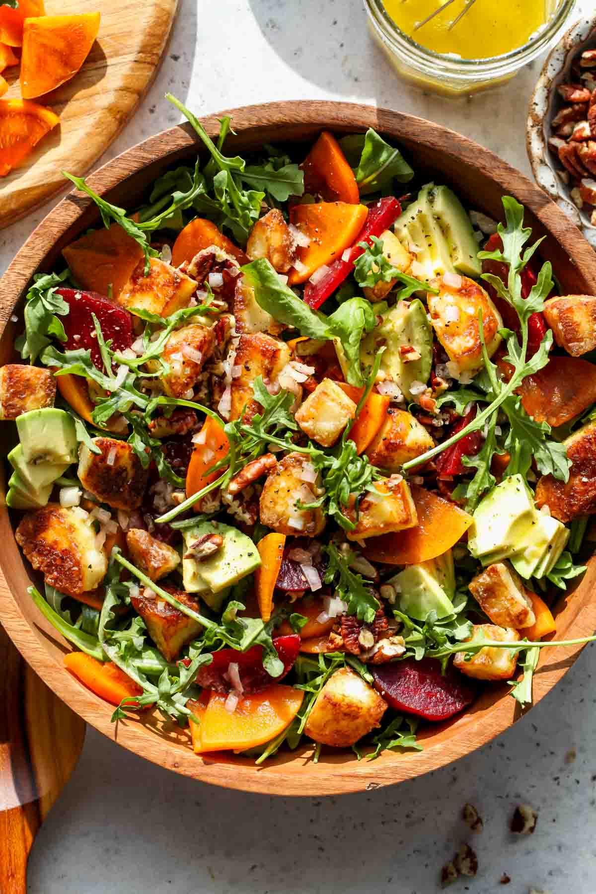 Arugula and persimmon salad in a wooden serving bowl