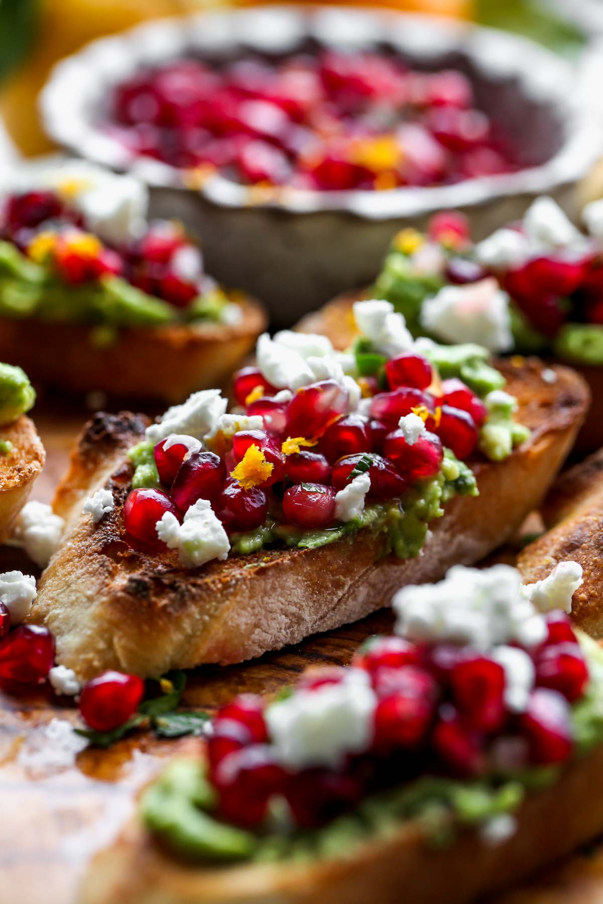 Single avocado crostini topped with pomegranate salsa and goat cheese