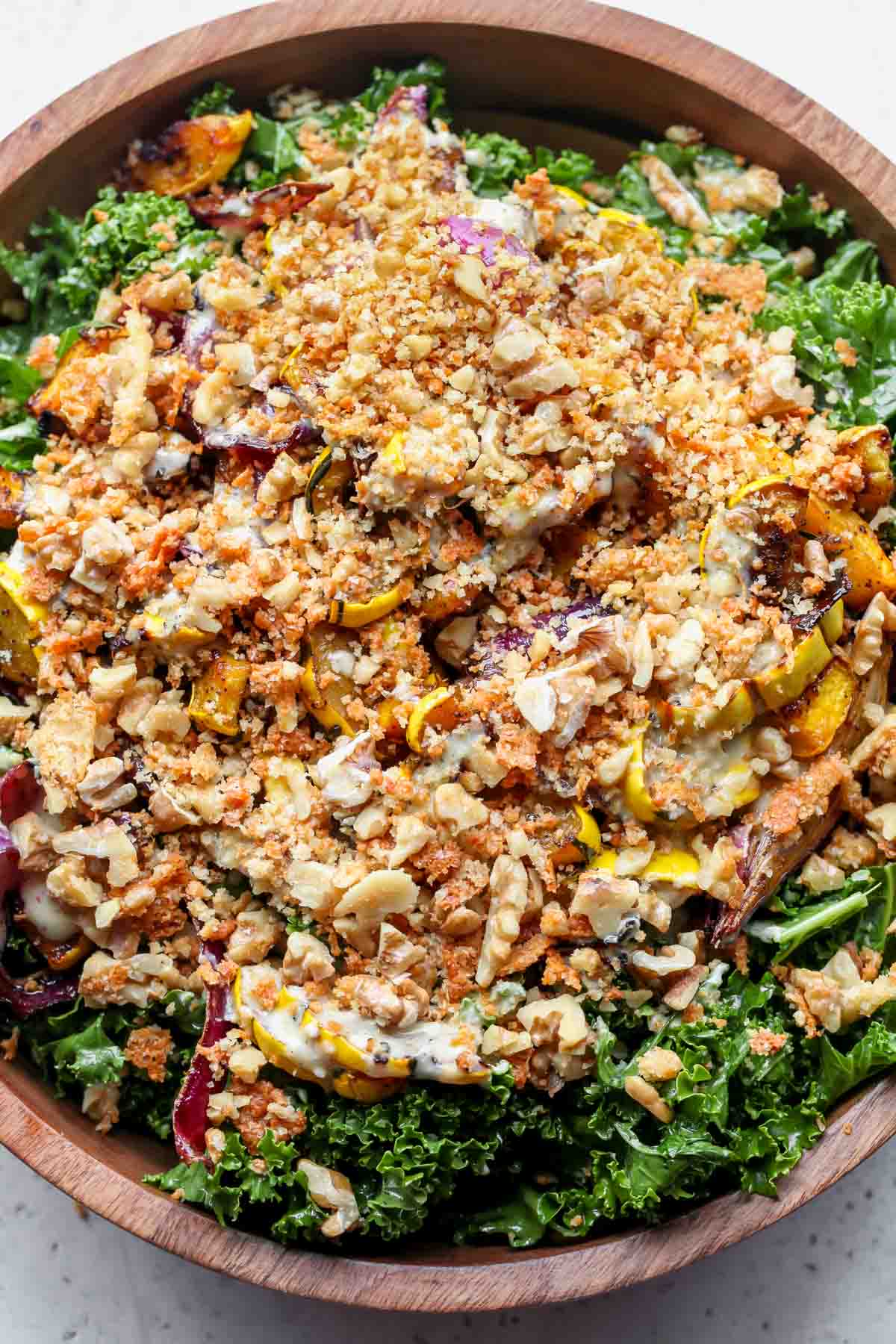 Walnut-parmesan breadcrumbs being scattered over assembled salad
