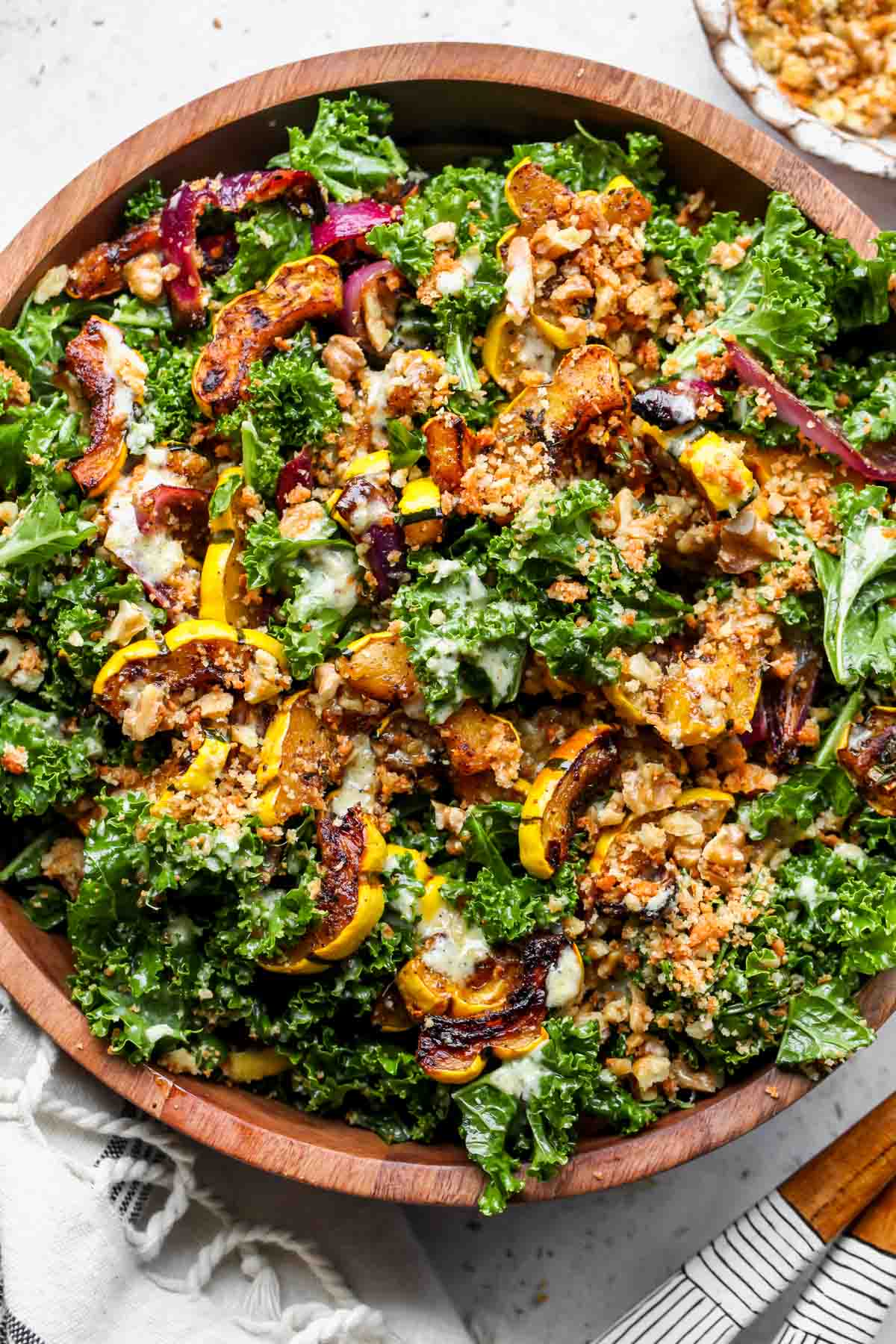 Roasted squash salad with kale in a wooden serving bowl