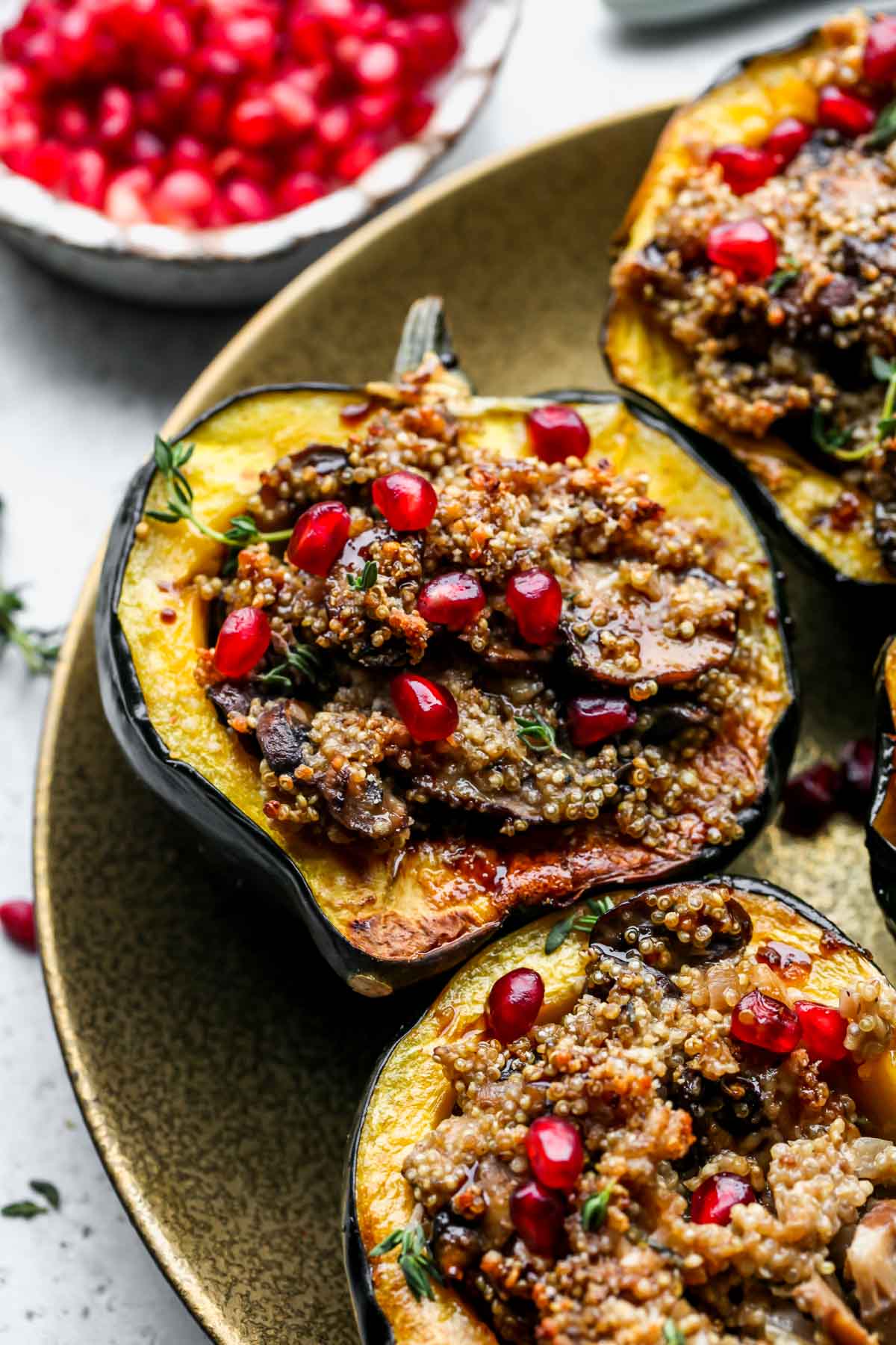 Quinoa stuffed acorn squash halves arranged on a gold plate