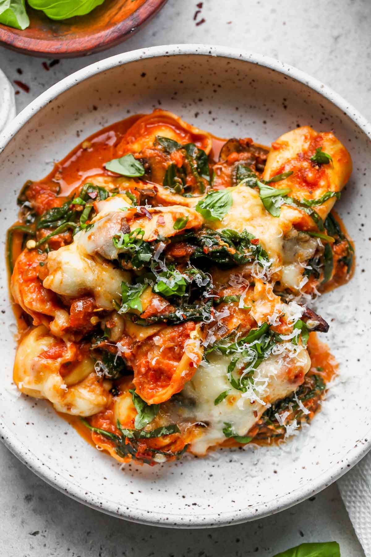 Single portion of baked cheese tortellini served in a white bowl