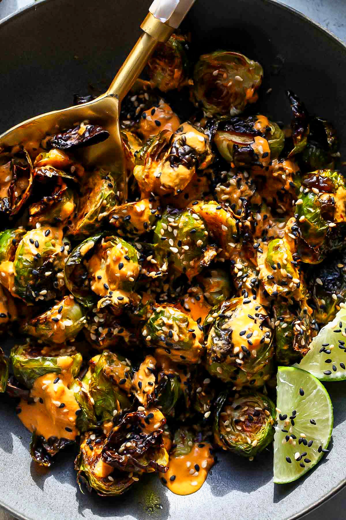 Serving spoon taking a portion of roasted veggies out of a bowl