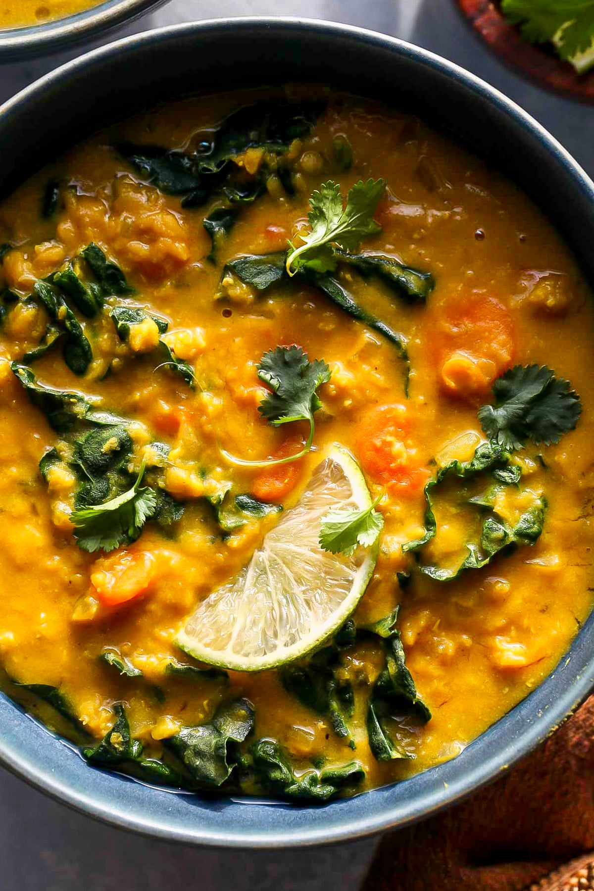 Close up of vegan lentil soup in a blue serving bowl