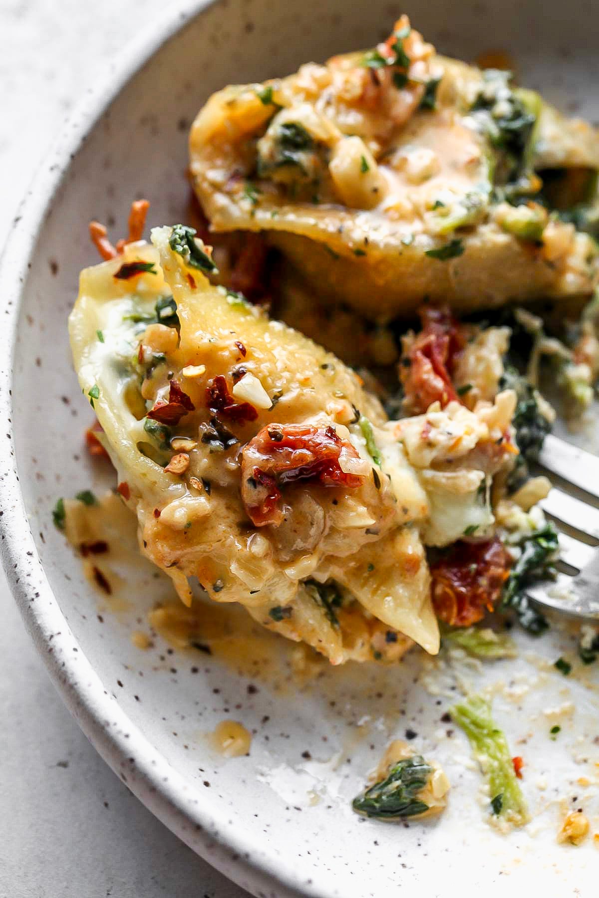 Two stuffed shells on a white serving plate