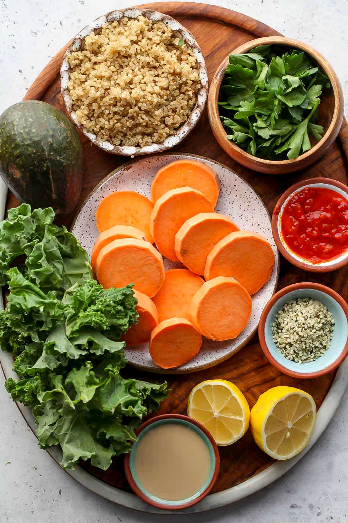 Recipe ingredients in separate bowls arranged on a wooden serving platter