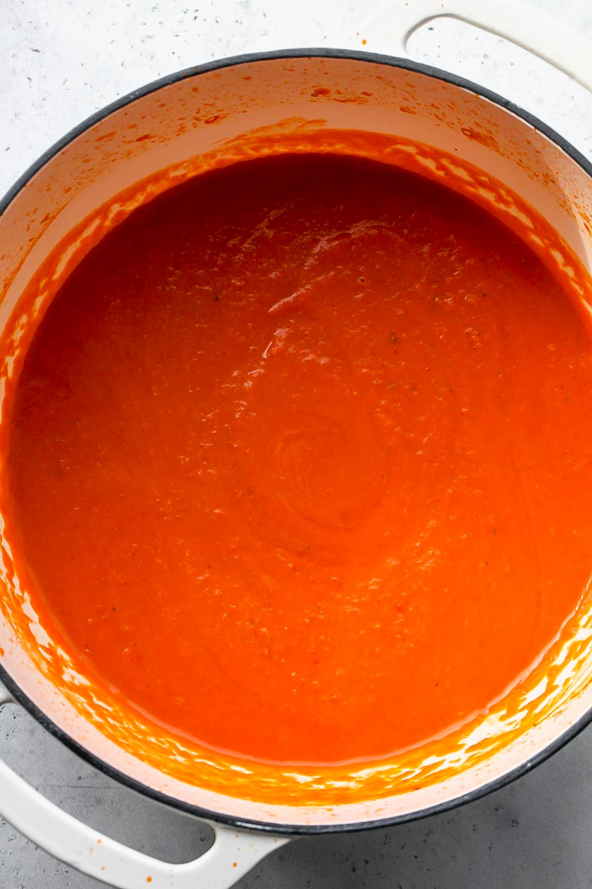 Tomato and roasted red pepper soup after being blended until smooth in a white pot