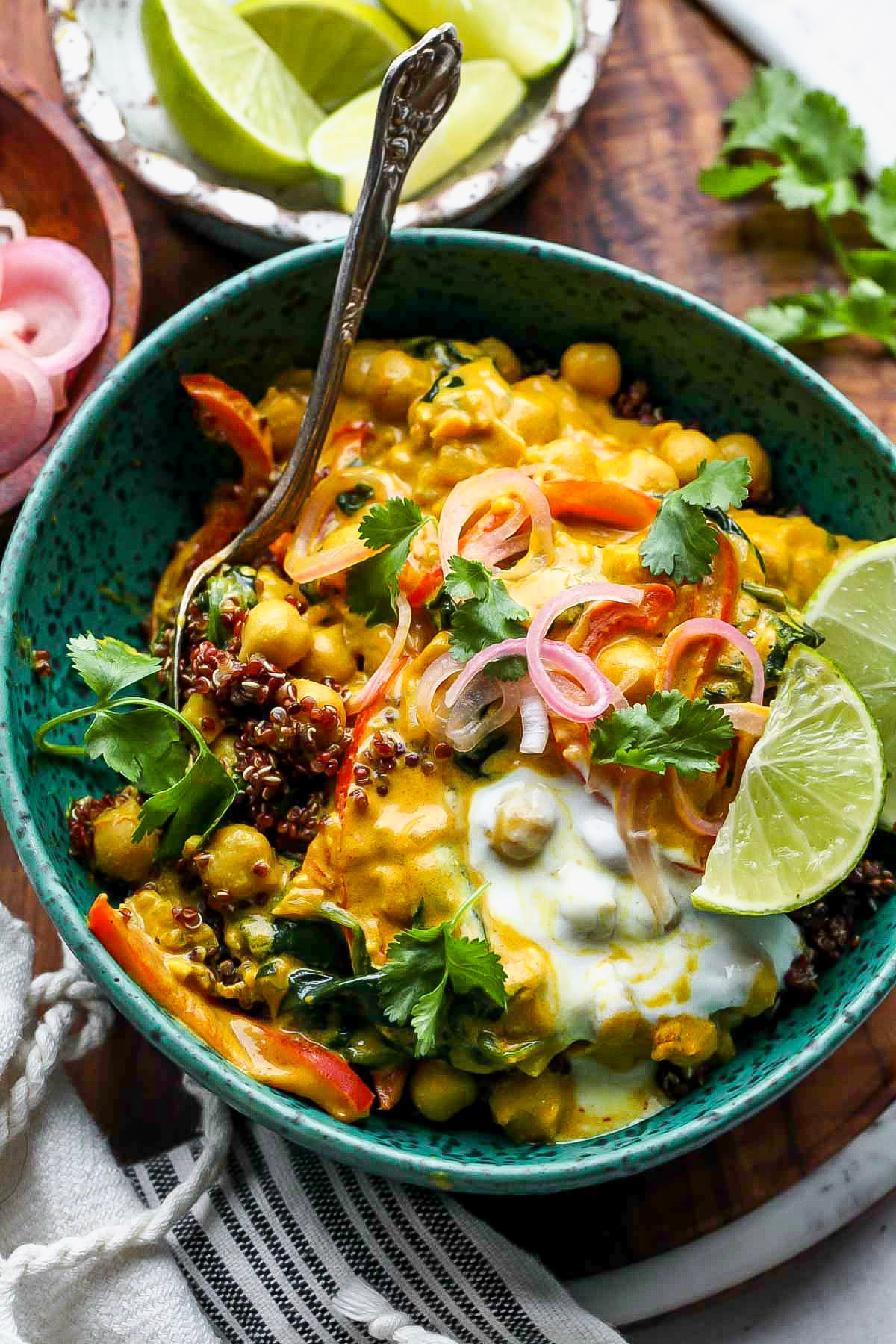A spoon digging into a bowl of vegan chickpea curry