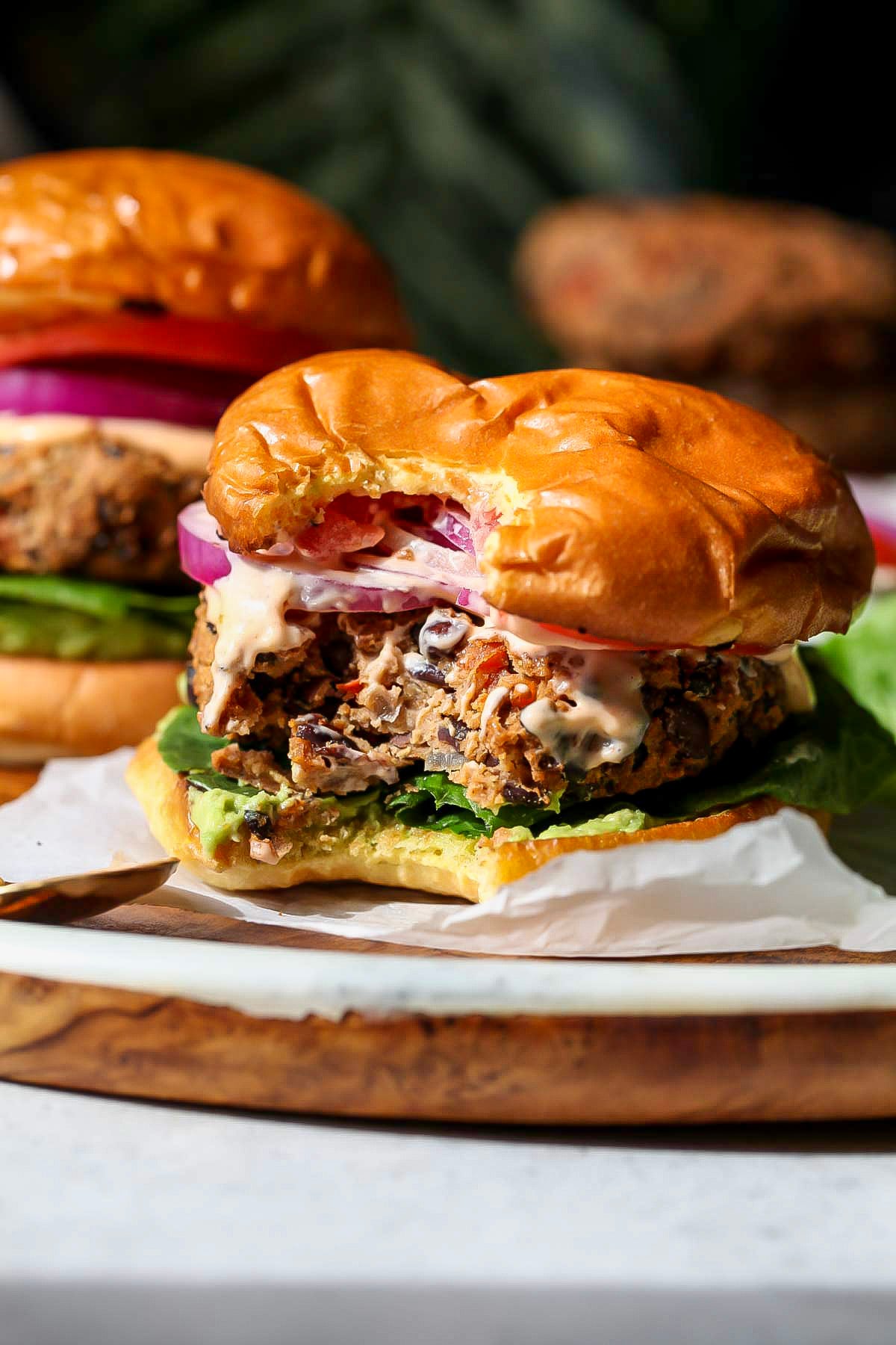 A bite being taken out of chipotle black bean burger to show inside of patty.