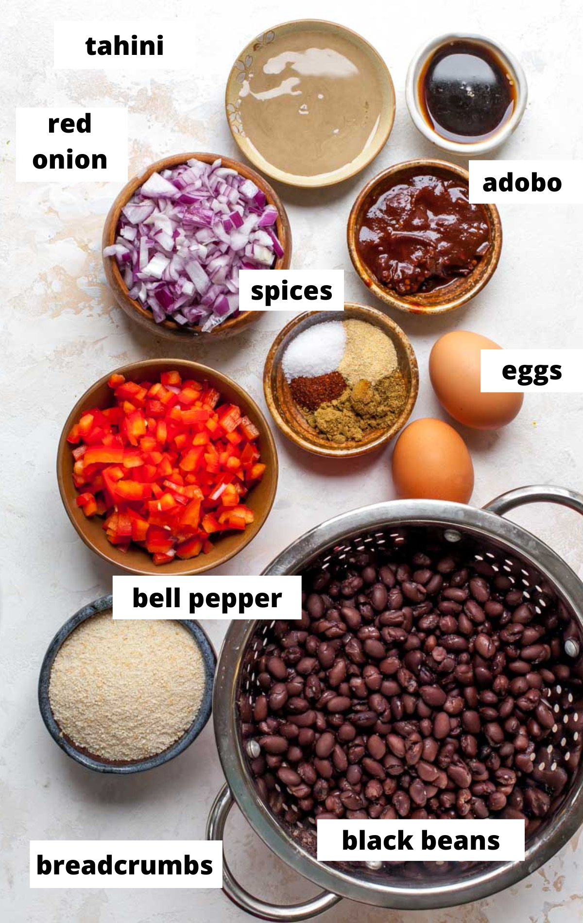 Recipe ingredients in separate bowls on a white surface with labels.