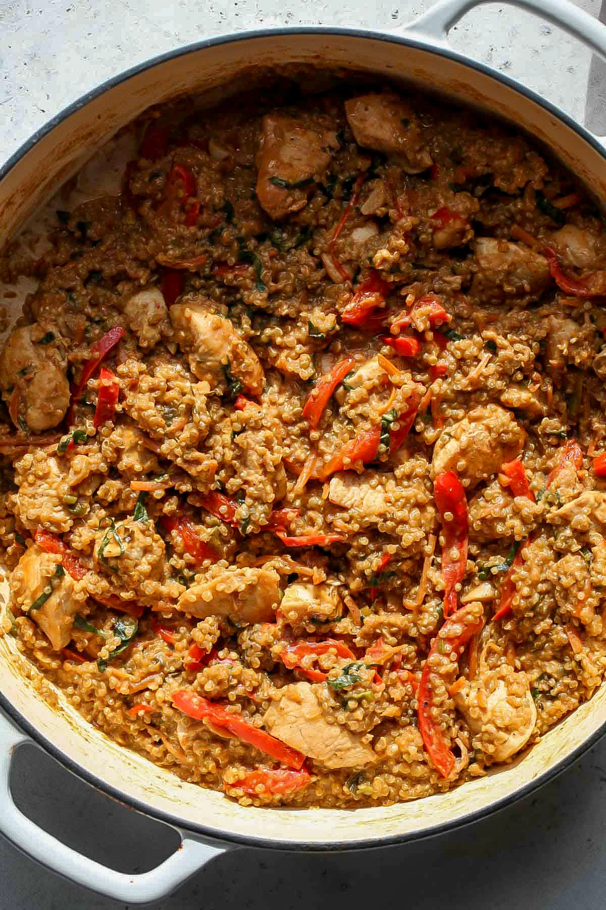 Pot uncovered to show grains soaking up the peanut sauce