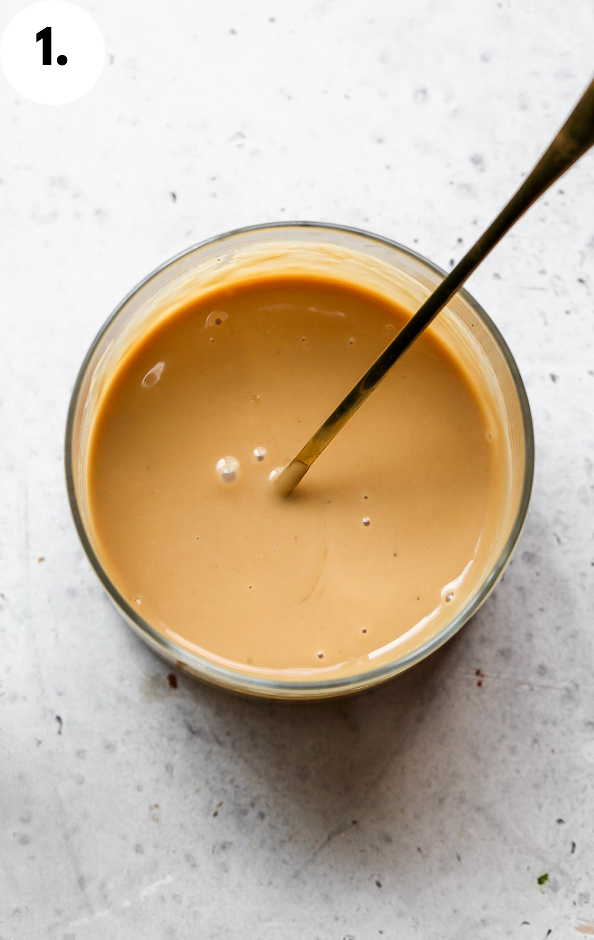 Sesame-teriyaki dressing being mixed until smooth in a glass jar.
