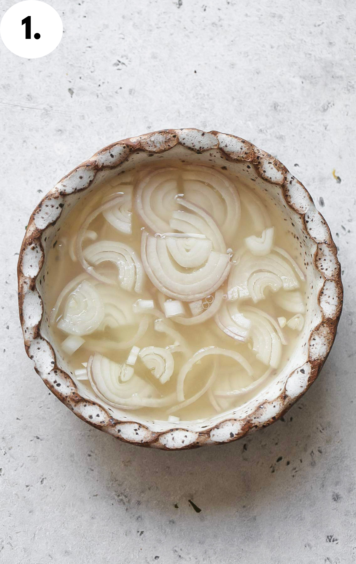 Sliced shallots soaking in a vinegar mixture.