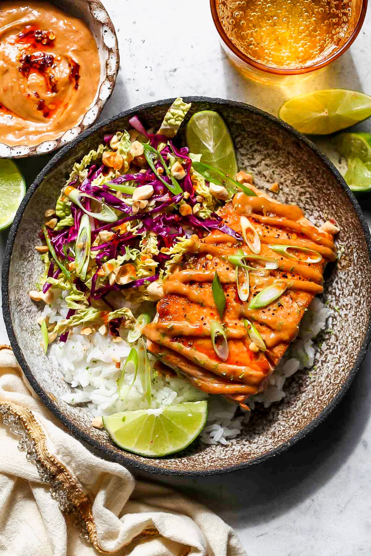 Seared salmon over rice drizzled with peanut sauce with a side of cabbage slaw.