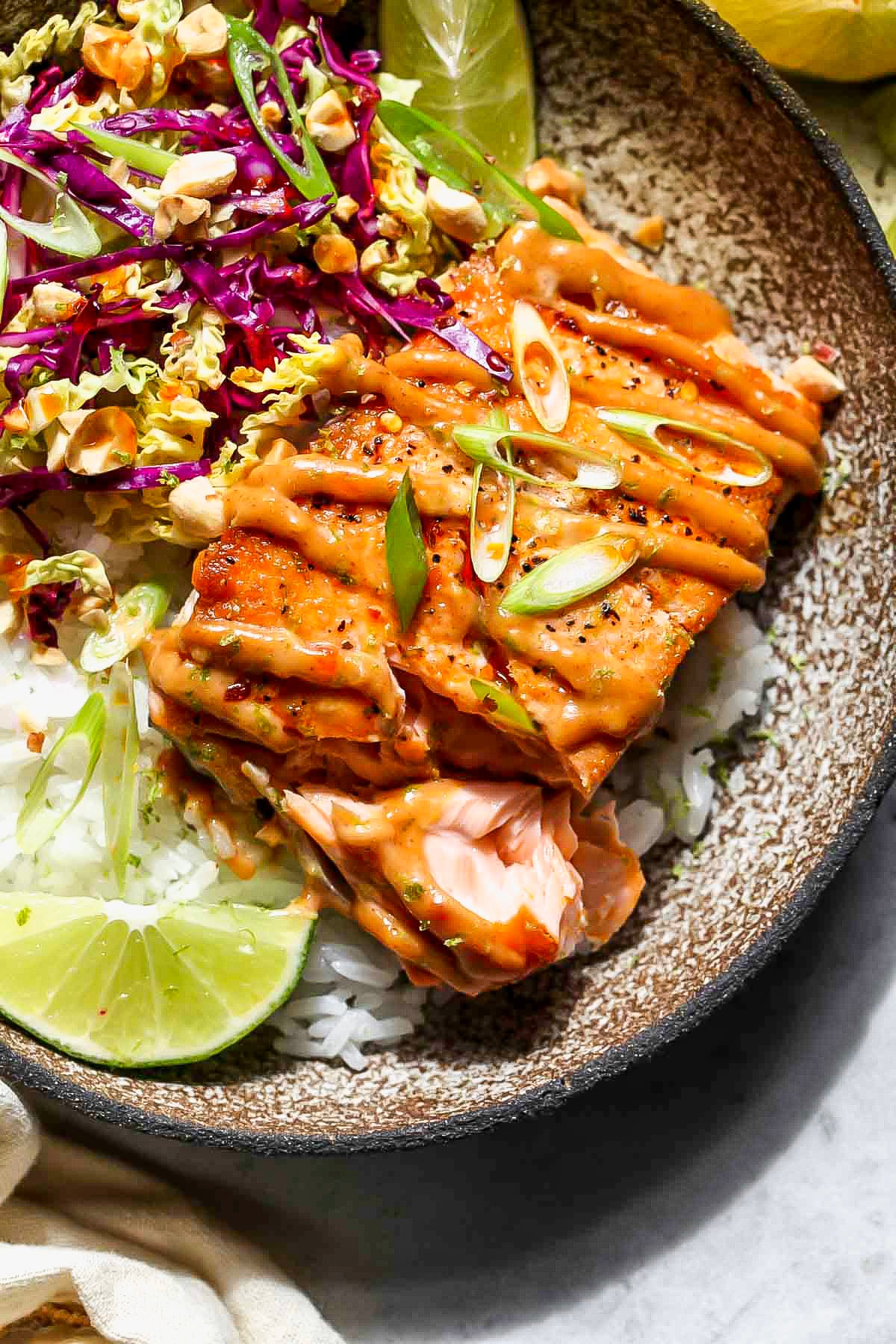 A fork digging into a piece of salmon to show inside flakiness.