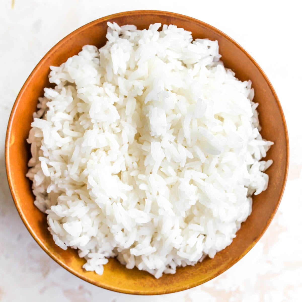 Cooked rice in a gold bowl.