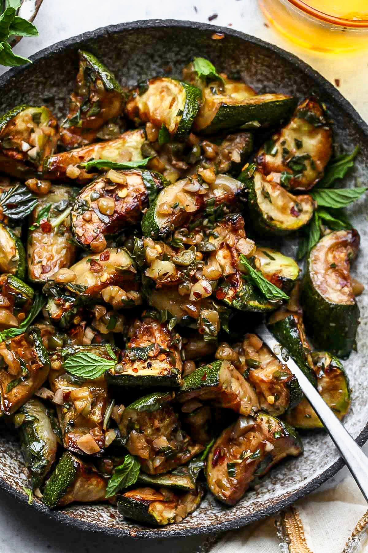 Garlic-herb sautéed zucchini in a grey serving bowl.