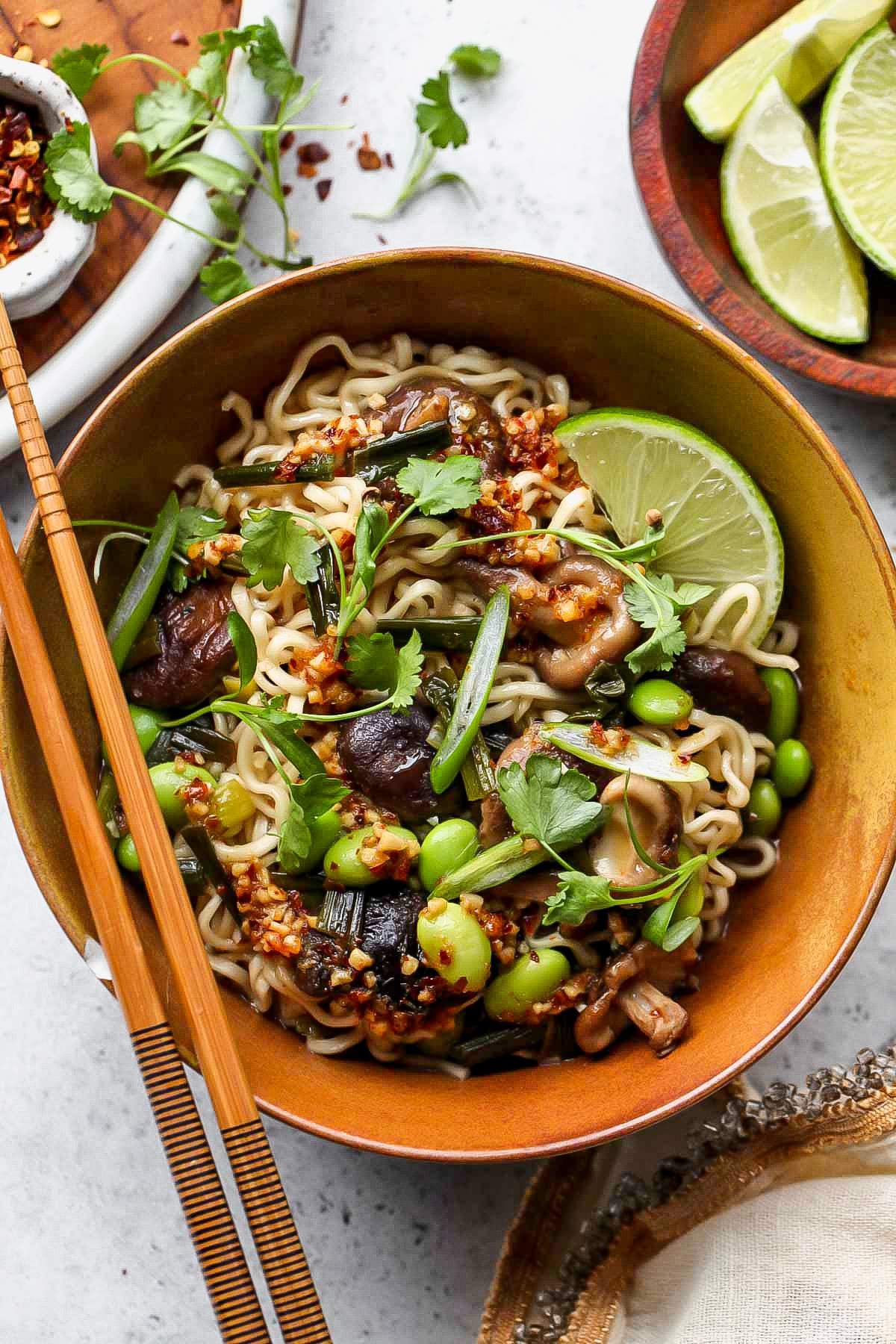 Spicy ramen noodles in a gold serving bowl topped with cilantro.