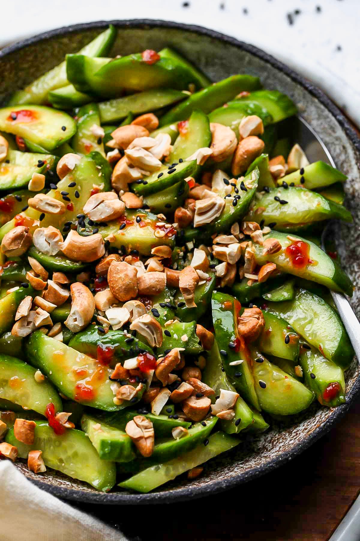 Asian cucumber salad in a grey serving bowl.