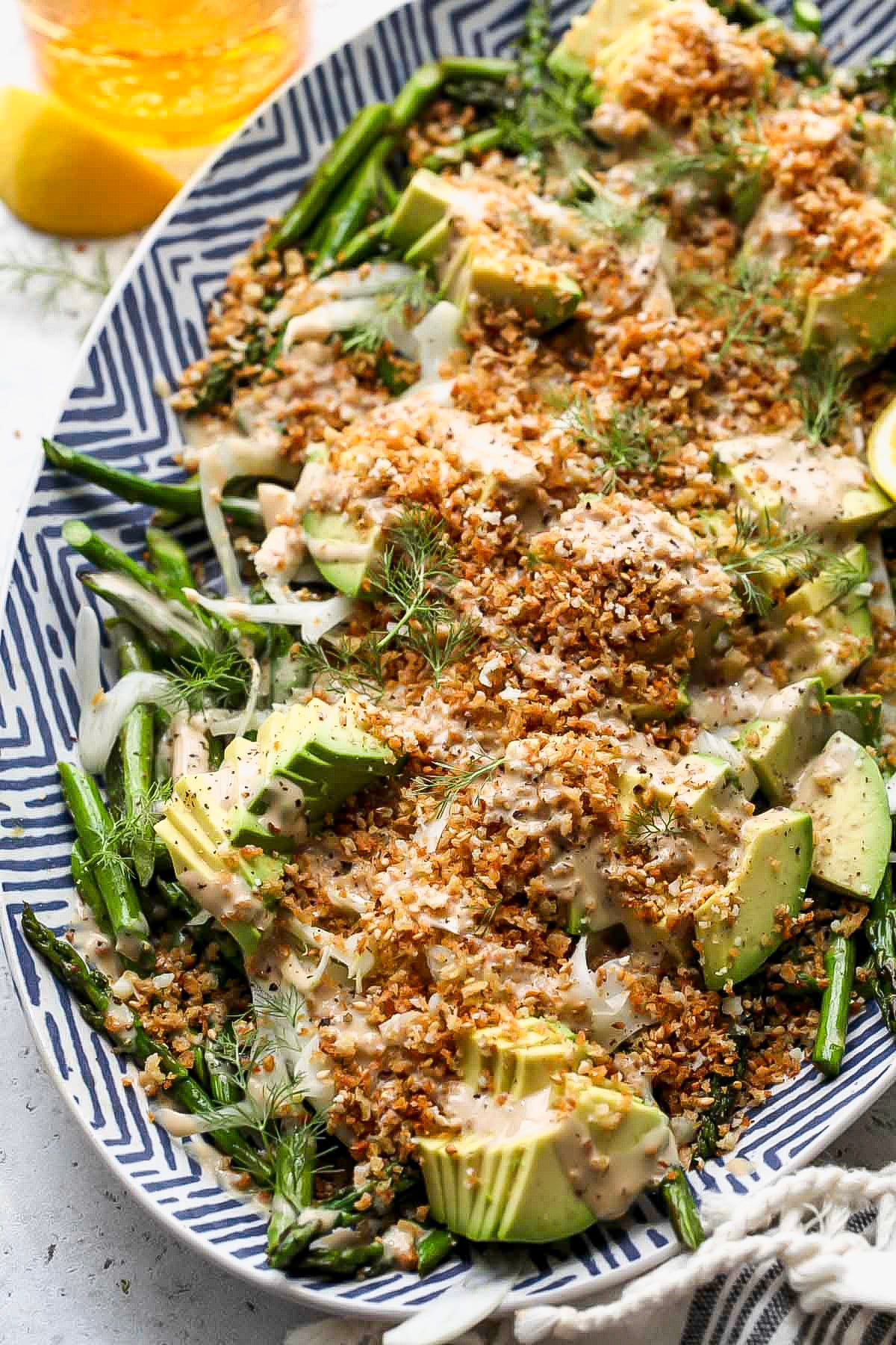 Asparagus salad recipe assembled on a serving platter topped with panko breadcrumbs.