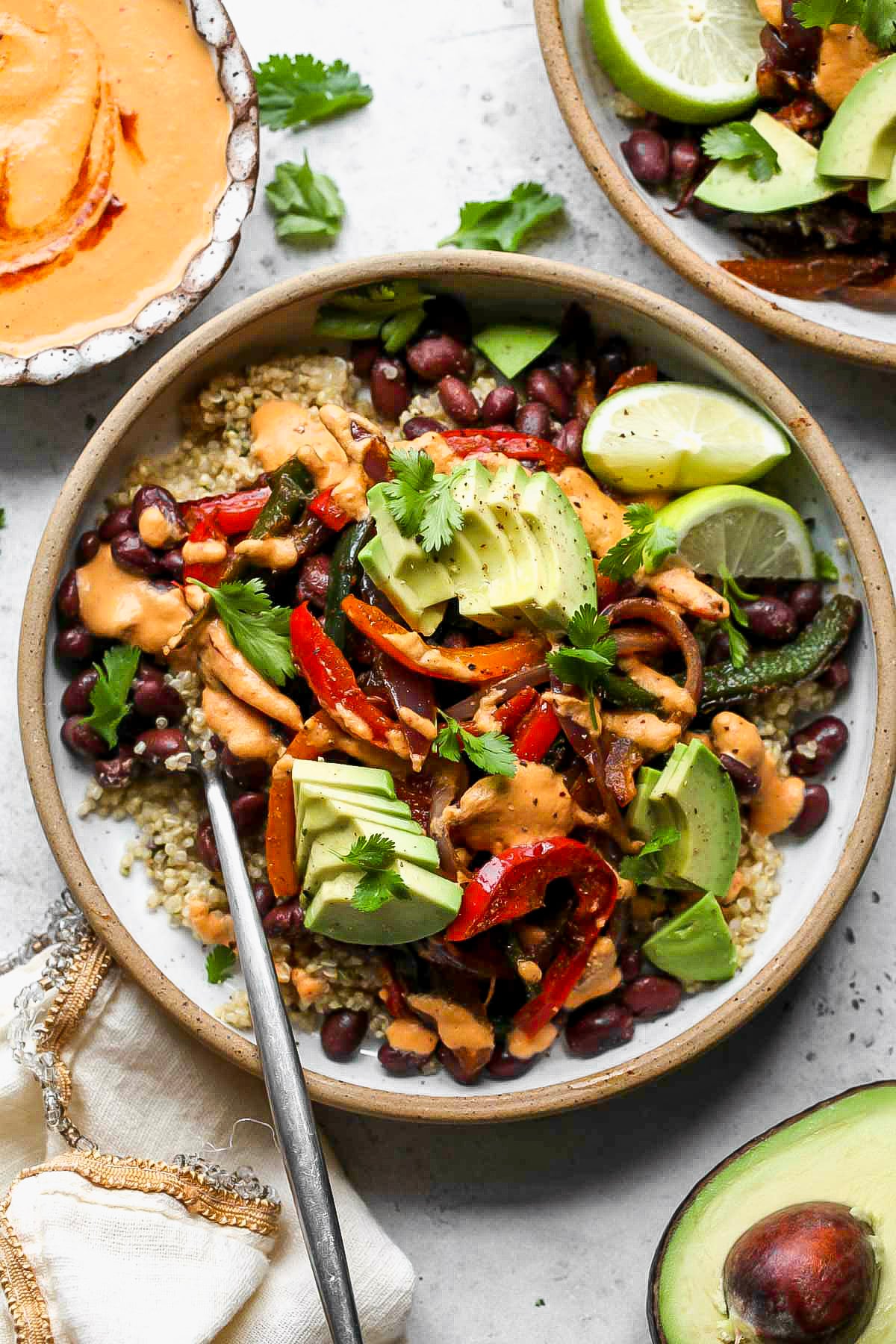 Vegan chipotle bowls topped with creamy chipotle sauce styled in a white speckled bowl.