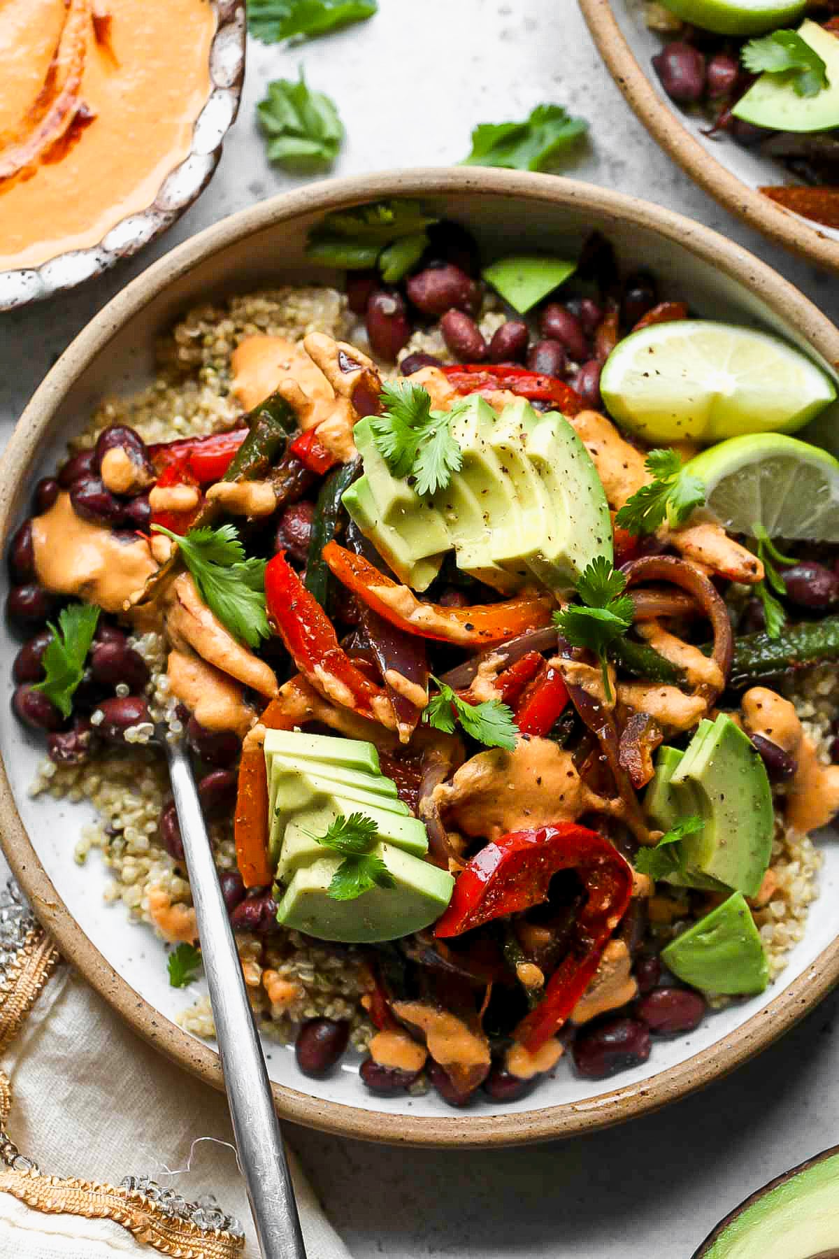 Vegan chipotle bowls being assembled in a white serving bowl.