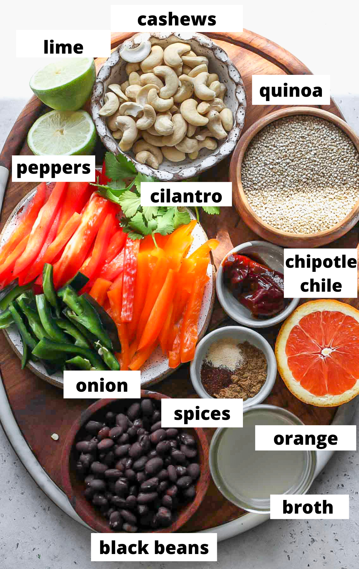 Recipe ingredients in separate bowls on a wooden tray with labels.