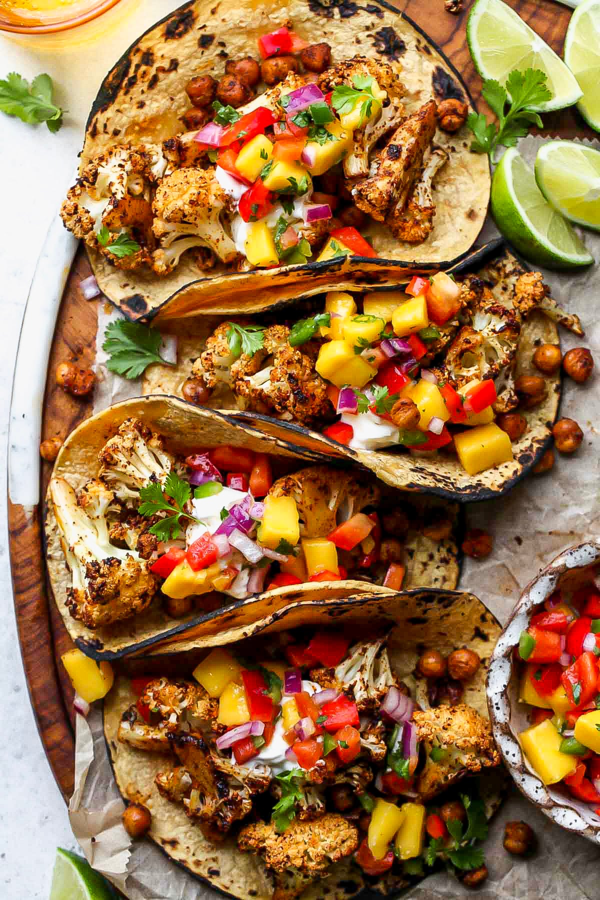 Vegan cauliflower and chickpea tacos topped with mango salsa and cilantro.