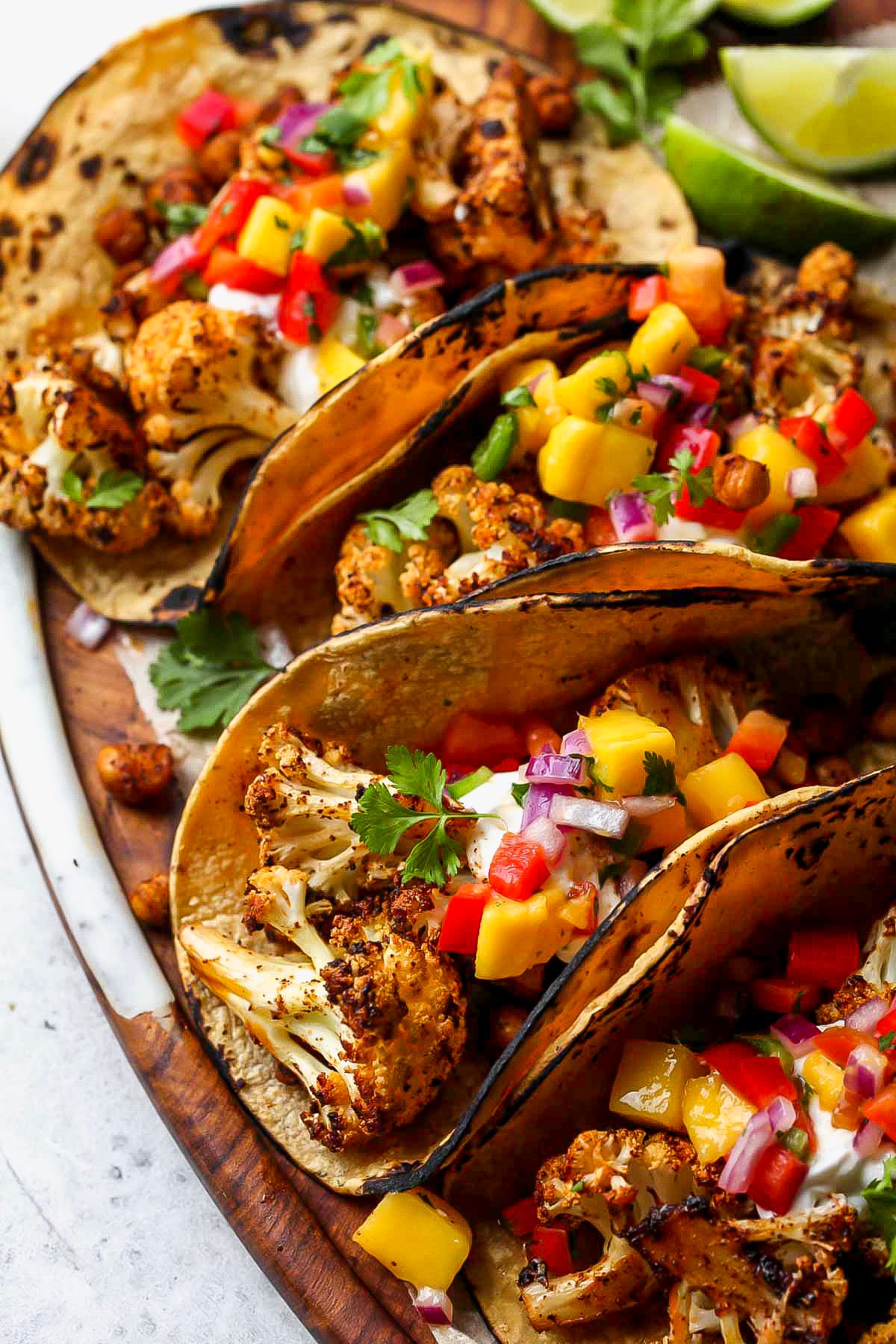 Chili roasted cauliflower and chickpea tacos arranged on a serving platter.