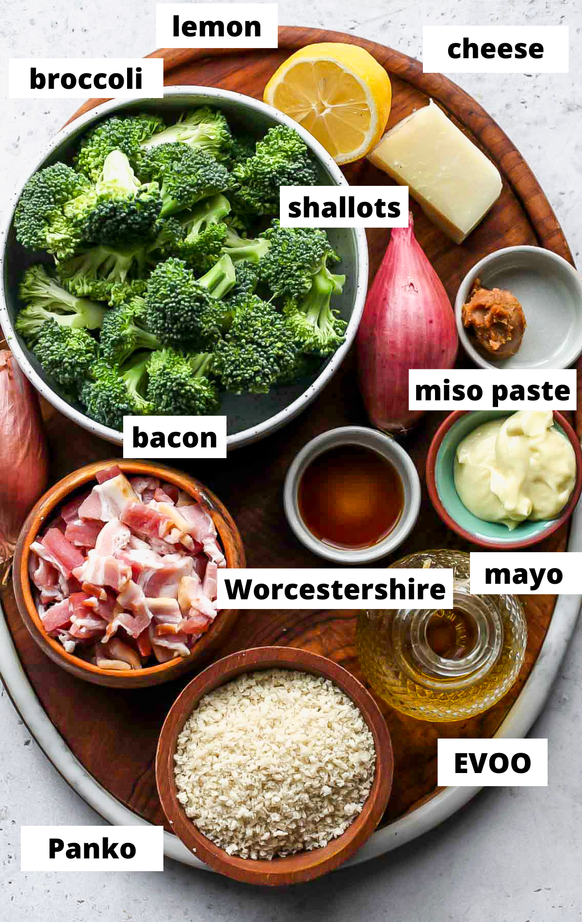 Recipe ingredients in separate bowls on a wooden serving platter with labels.