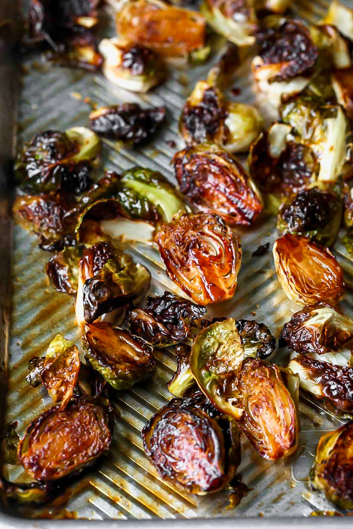 Roasted Brussels sprouts on a silver sheet pan.