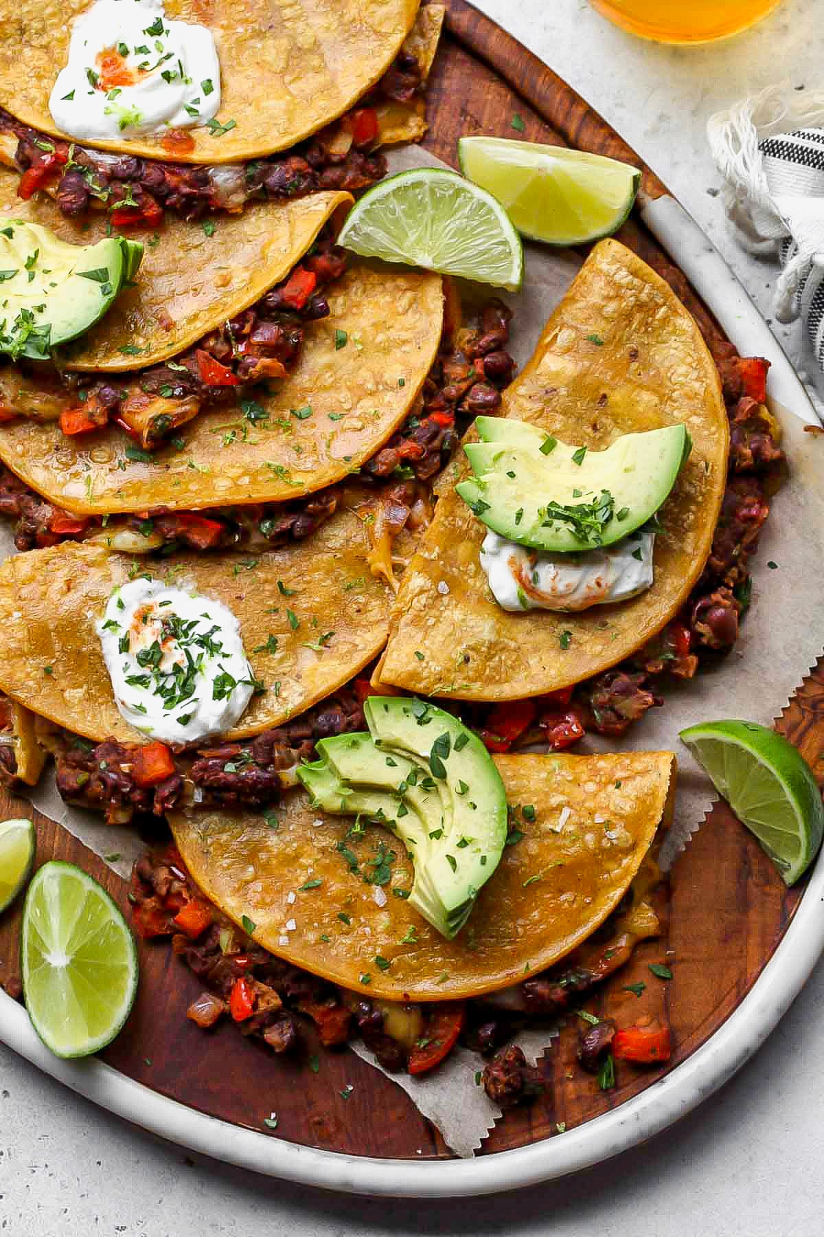 Crispy black bean tacos assembled on a large cutting board.