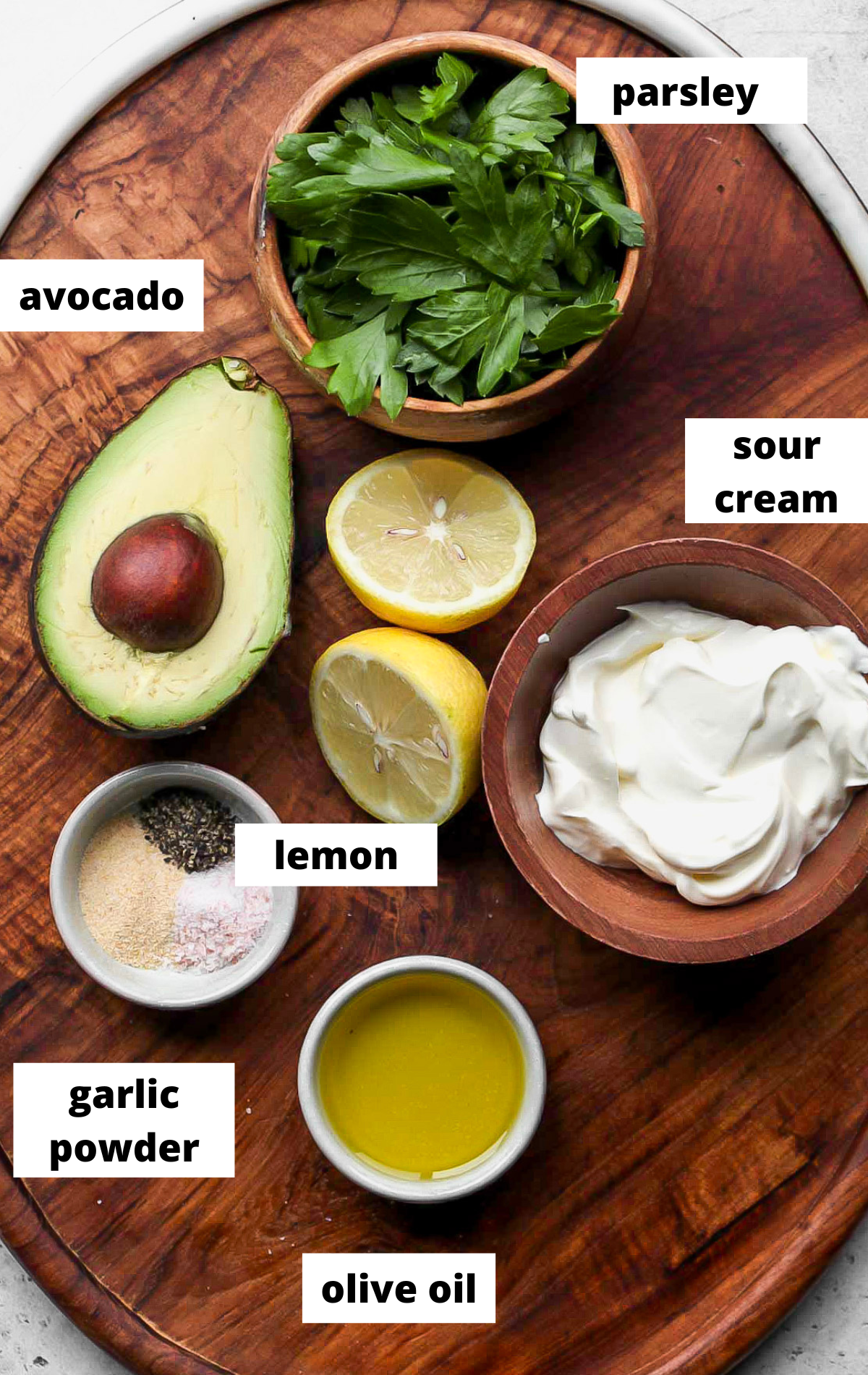 Recipe ingredients in separate bowls with labels on a wooden serving platter.