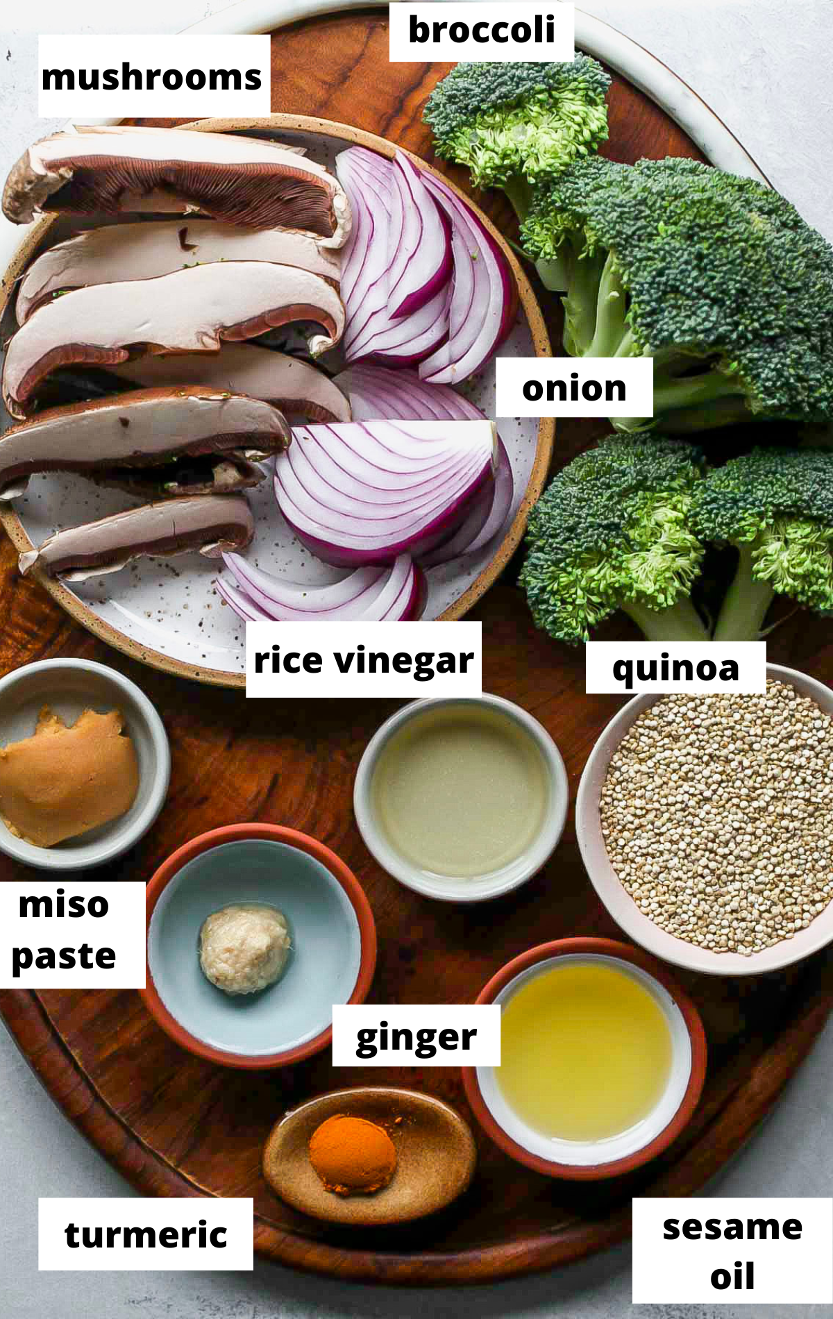 Recipe ingredients in separate bowls with labels on a wooden platter.