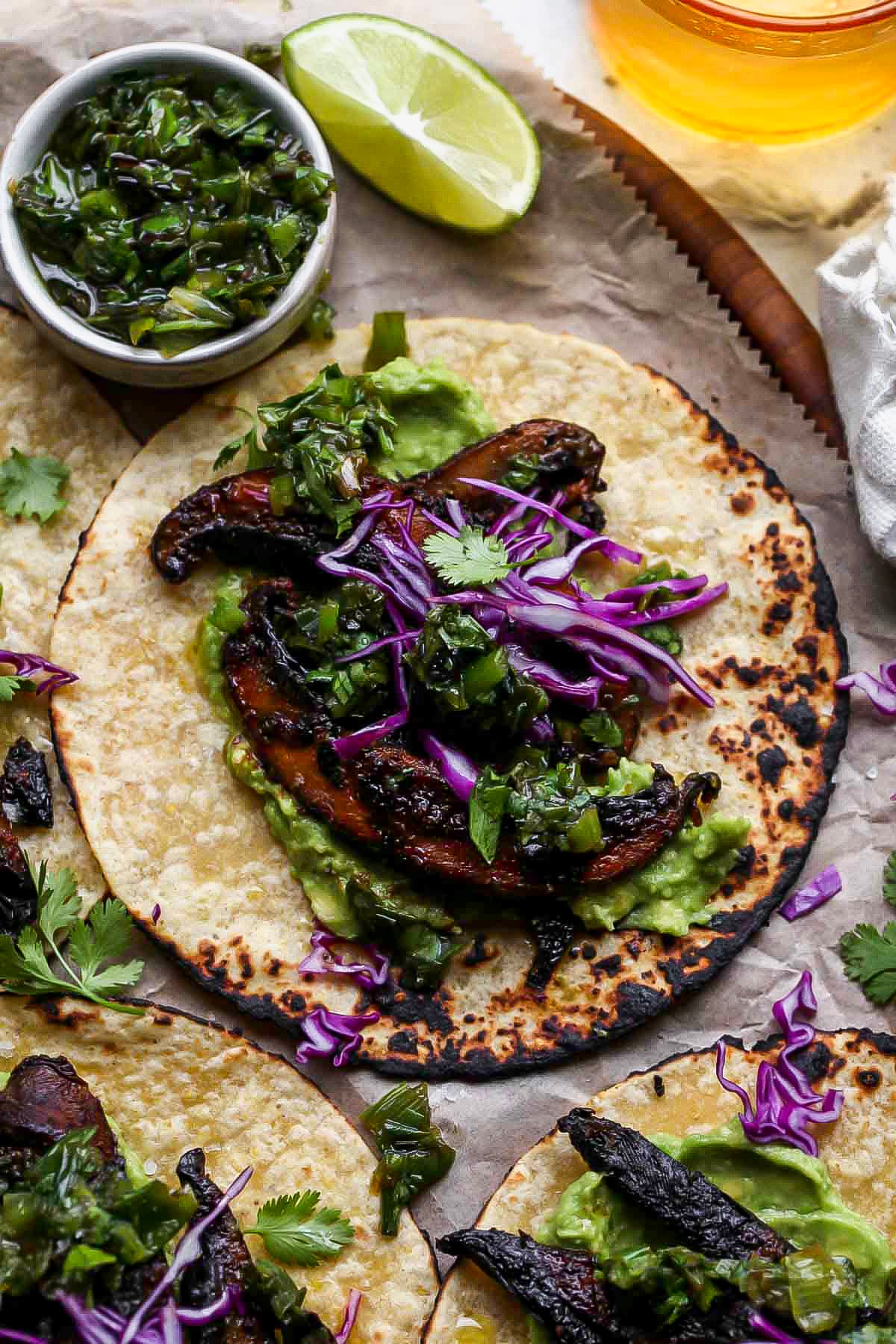 One portobello taco topped with charred scallion salsa verde and purple cabbage.