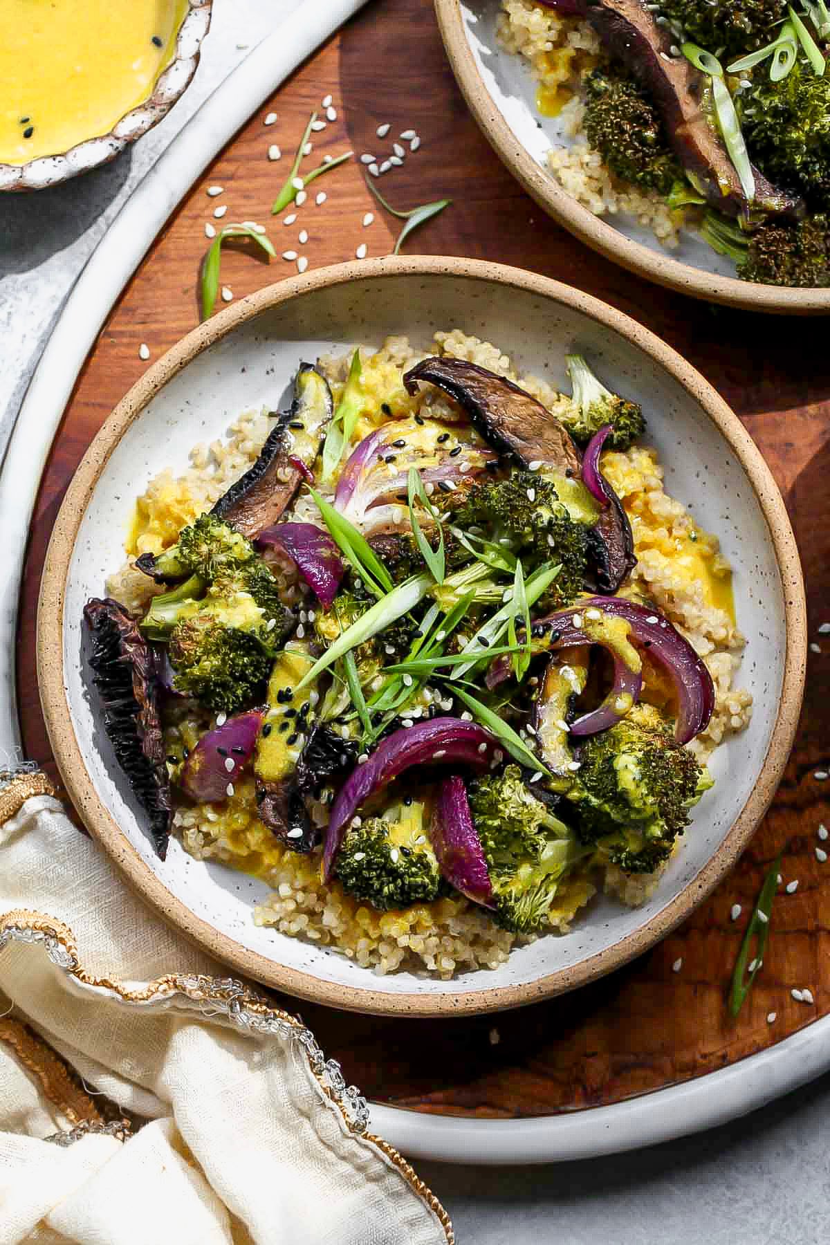 Roasted Veggie Quinoa Bowls topped with miso-turmeric dressing in a white serving bowl.