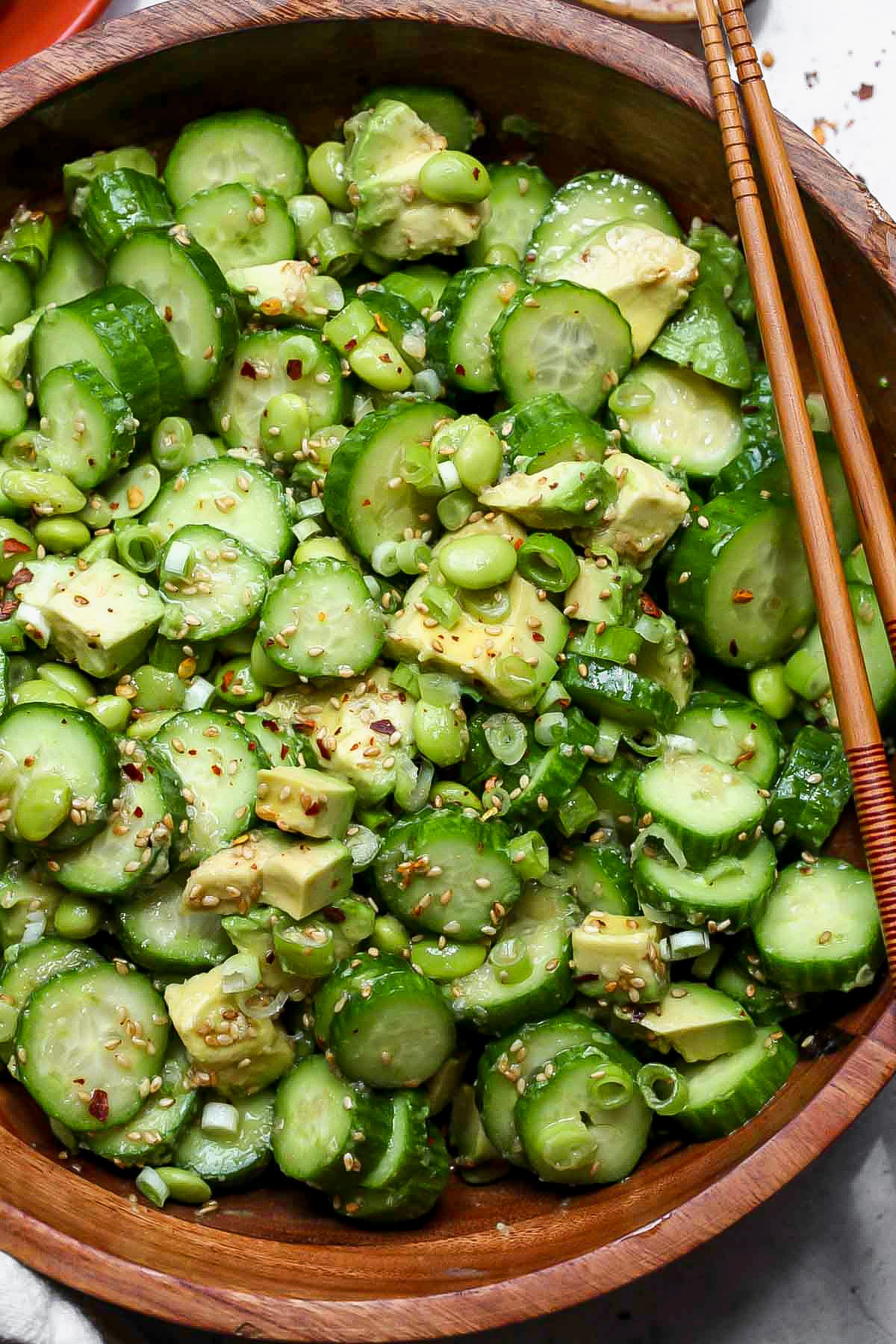 Cucumber Edamame Salad in a serving bowl with a set of chopsticks resting on the side.
