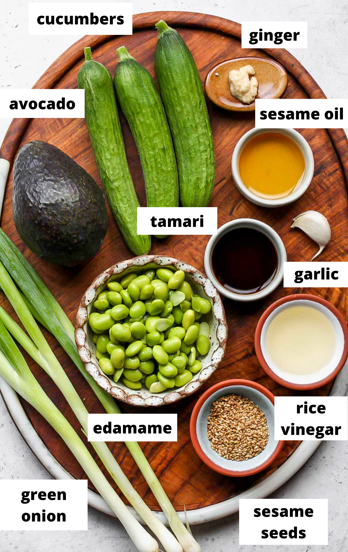 Recipe ingredients in separate bowls on wooden serving tray with labels.