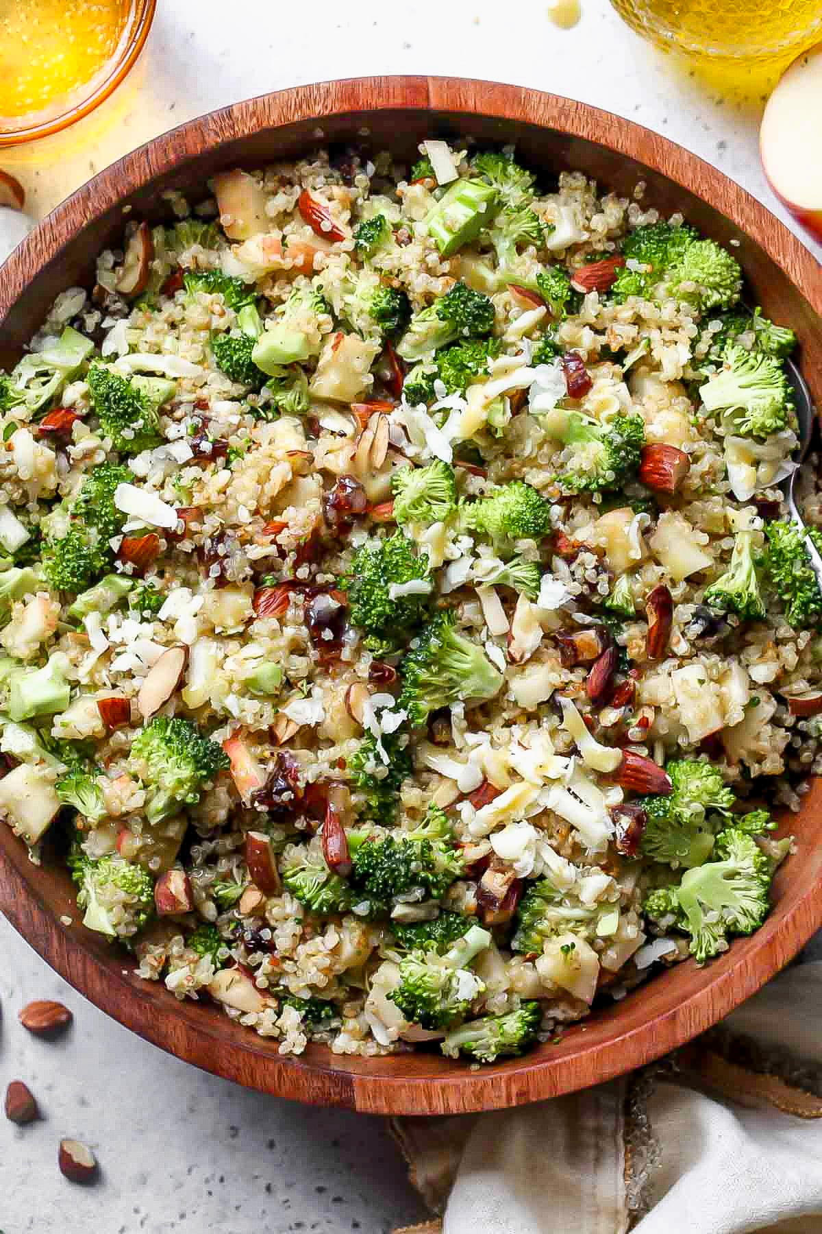 Broccoli quinoa salad assembled in a large serving bowl with a serving spoon resting on the right side.