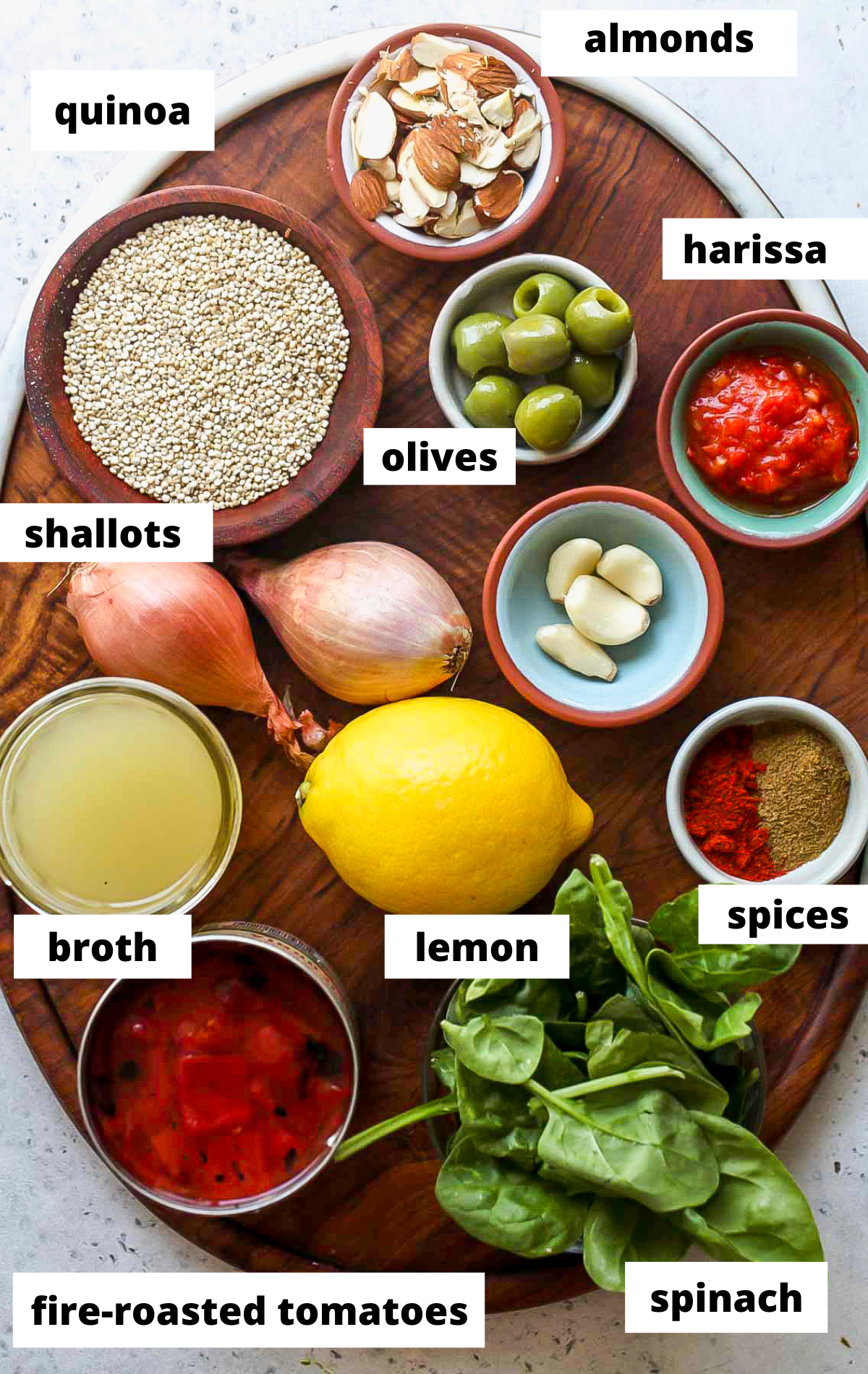Recipe ingredients in separate bowls on a wooden board with labels.