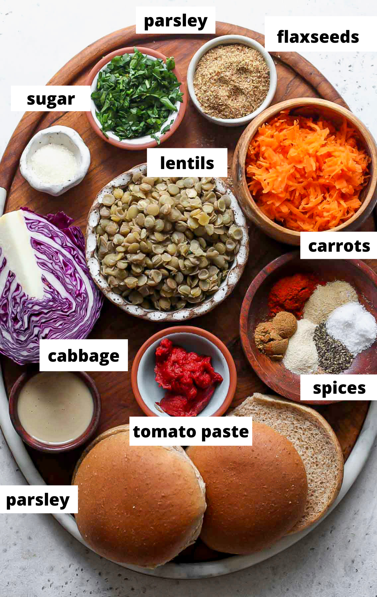 Recipe ingredients in separate bowls on a wooden platter with labels.