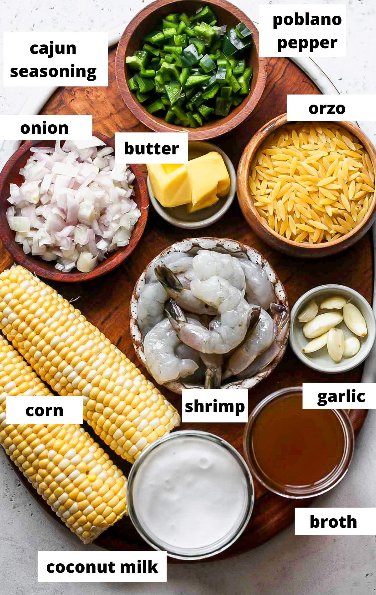 Recipe ingredients in separate bowls on a wooden board with labels.