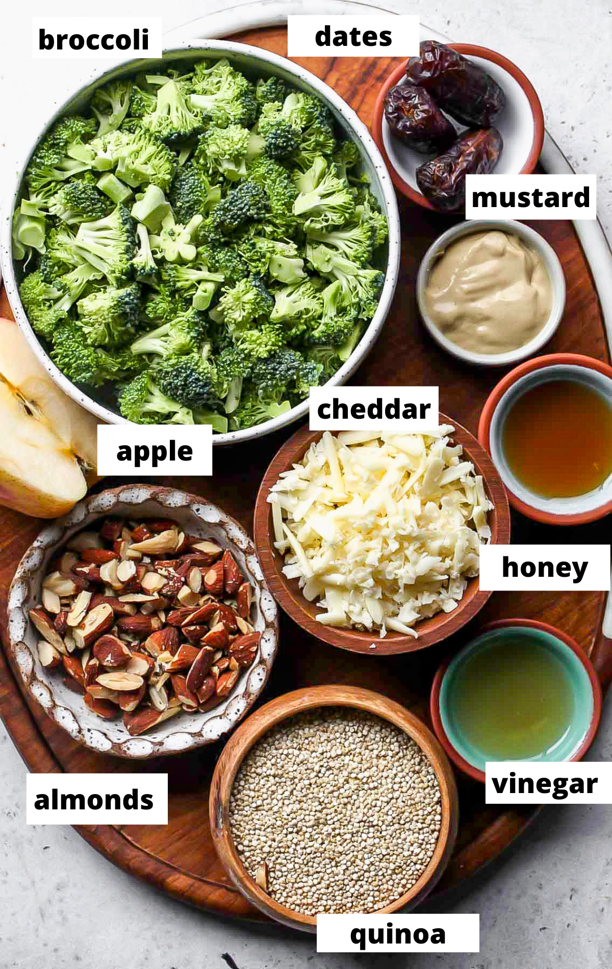 Recipe ingredients in separate bowls with labels on a wooden board.
