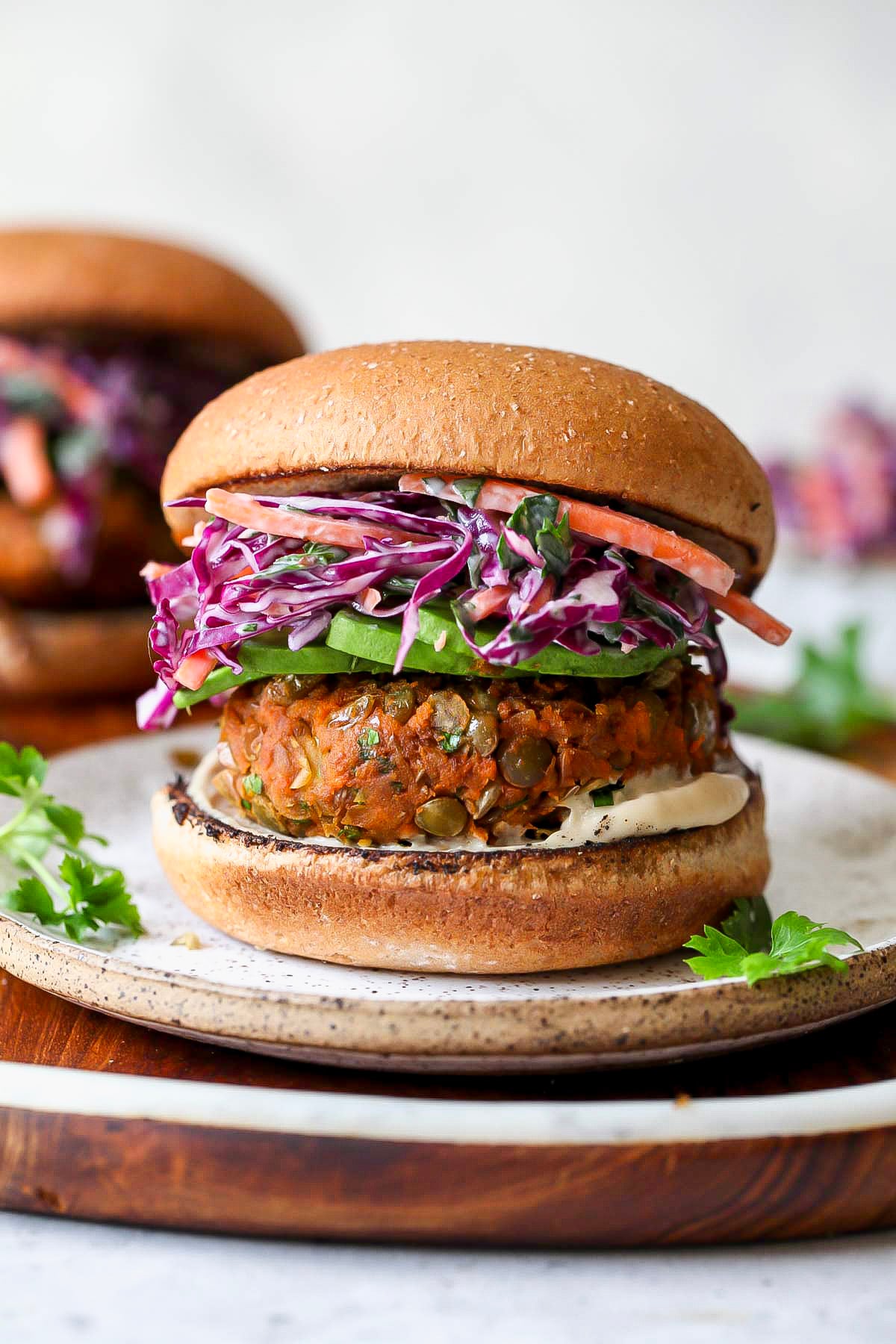 Assembled lentil burger on a small white plate.